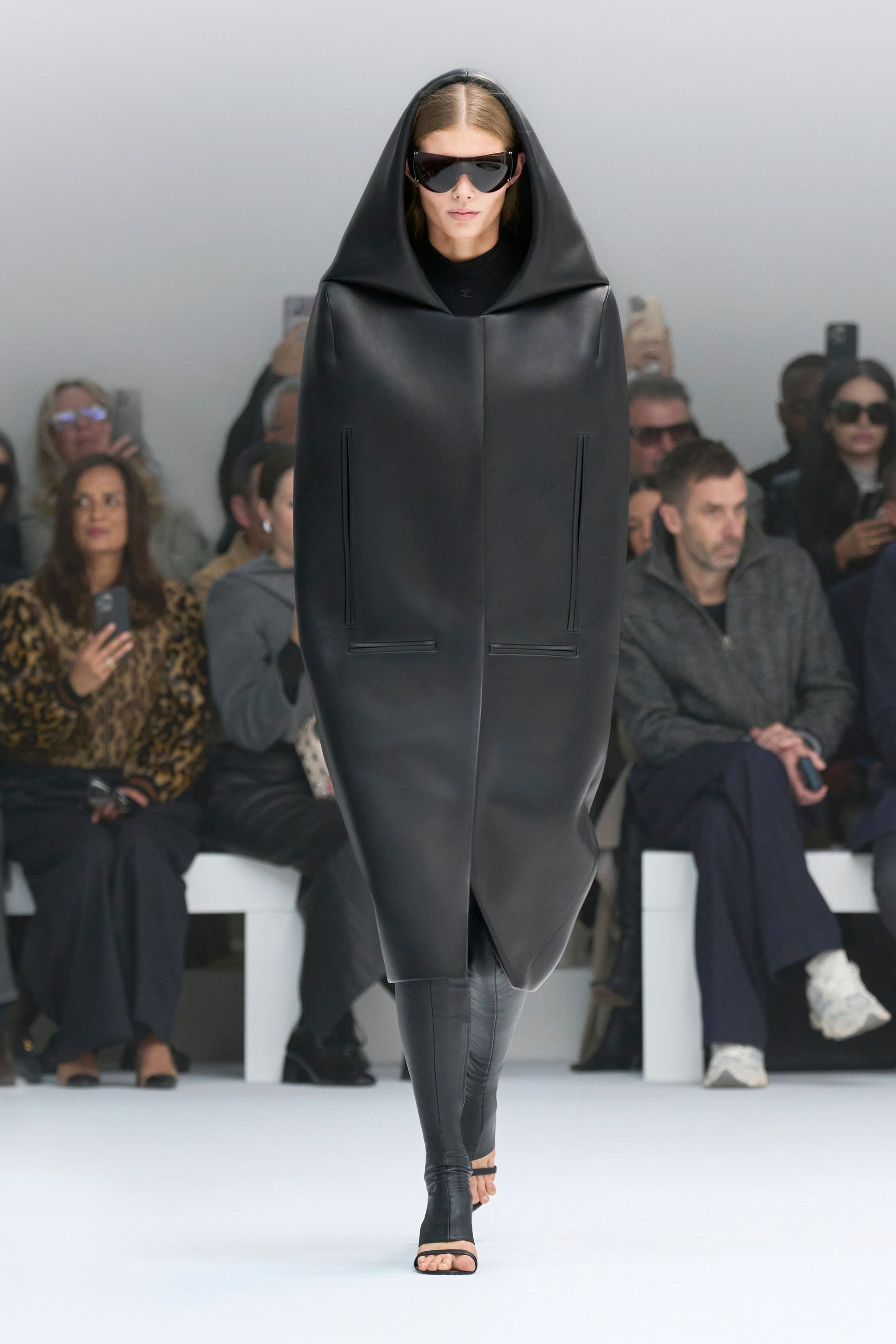 Elegant black hooded coat and leggings showcase Courrèges' futuristic fashion style.