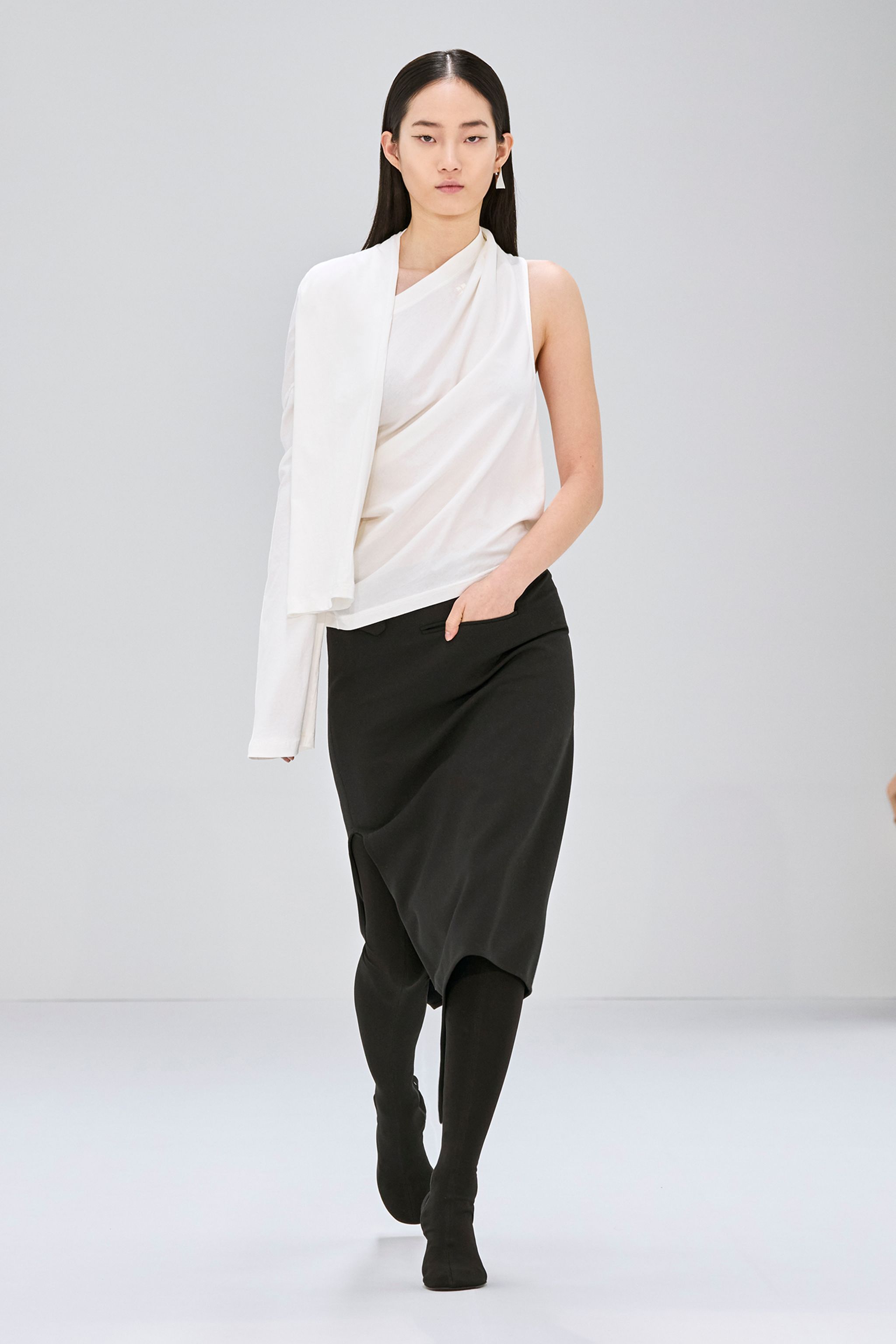 Elegant model in white and black Courrèges fashion, showcasing sophisticated modern style.