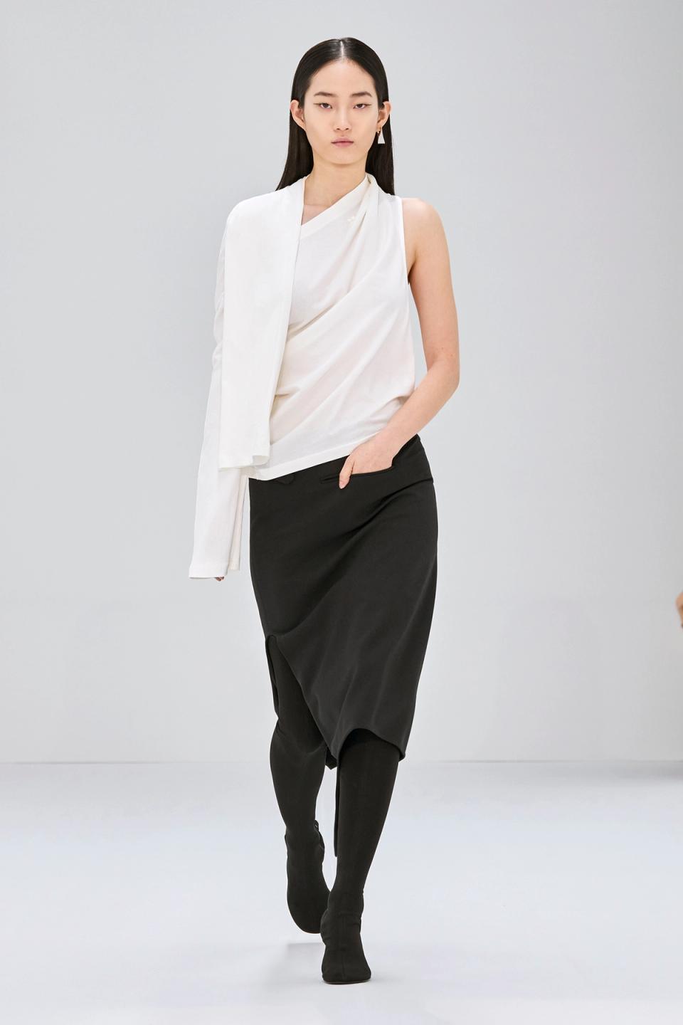 Elegant model in white and black Courrèges fashion, showcasing sophisticated modern style.