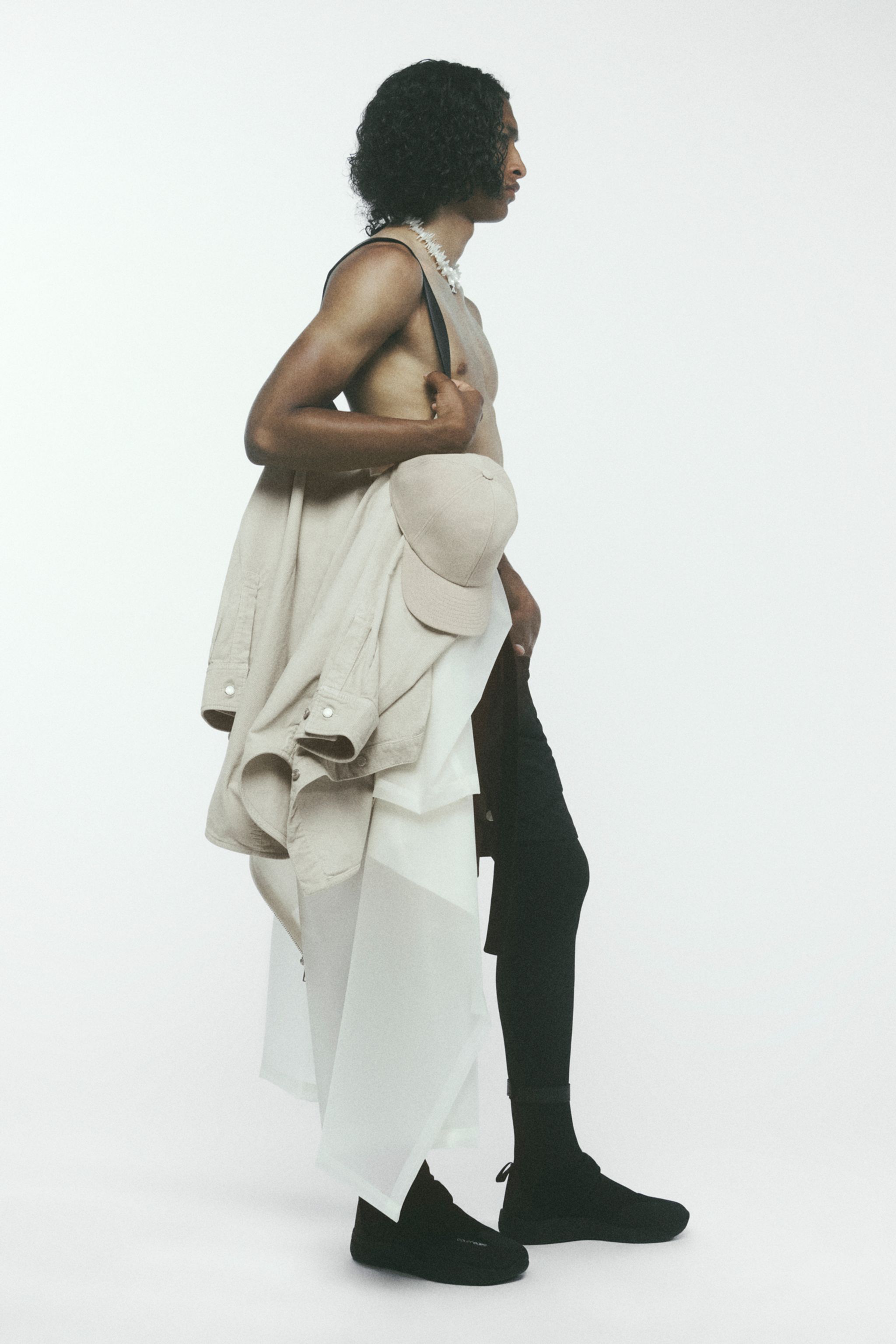 Elegant fashion model showcasing Courrèges apparel with layered black and beige styles.