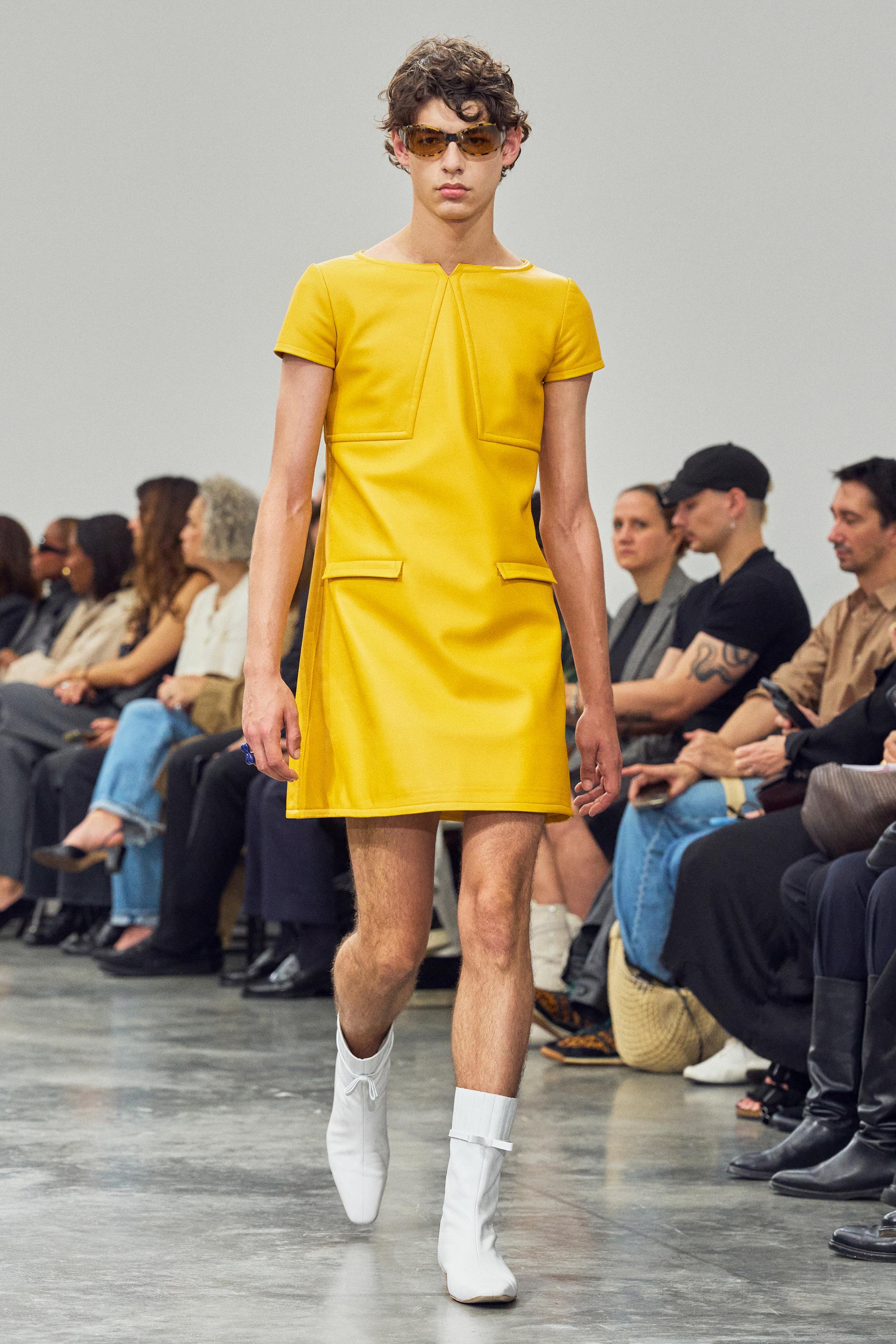 Elegant yellow dress by Courrèges showcased on a runway for a fashion ecommerce site.