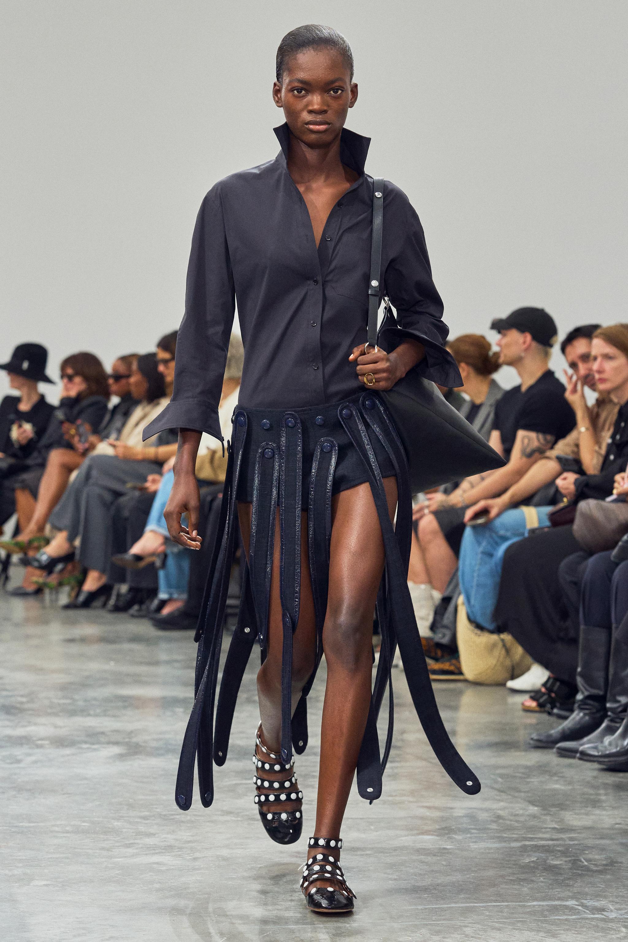 Elegant model walking runway showcasing sophisticated fashion pieces for Courrèges.