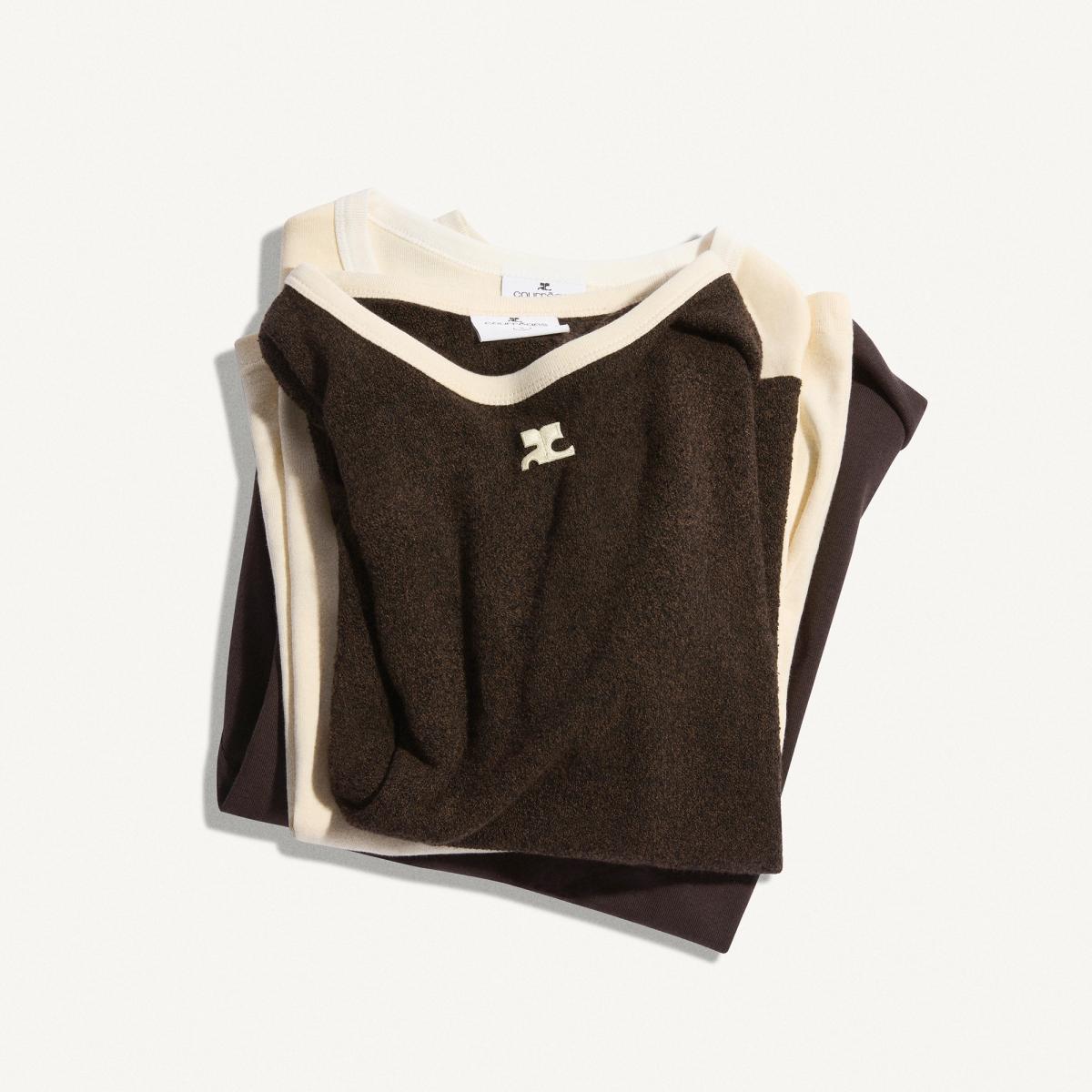 Elegant folded Courrèges sweaters in neutral tones, perfect for chic fashion style.
