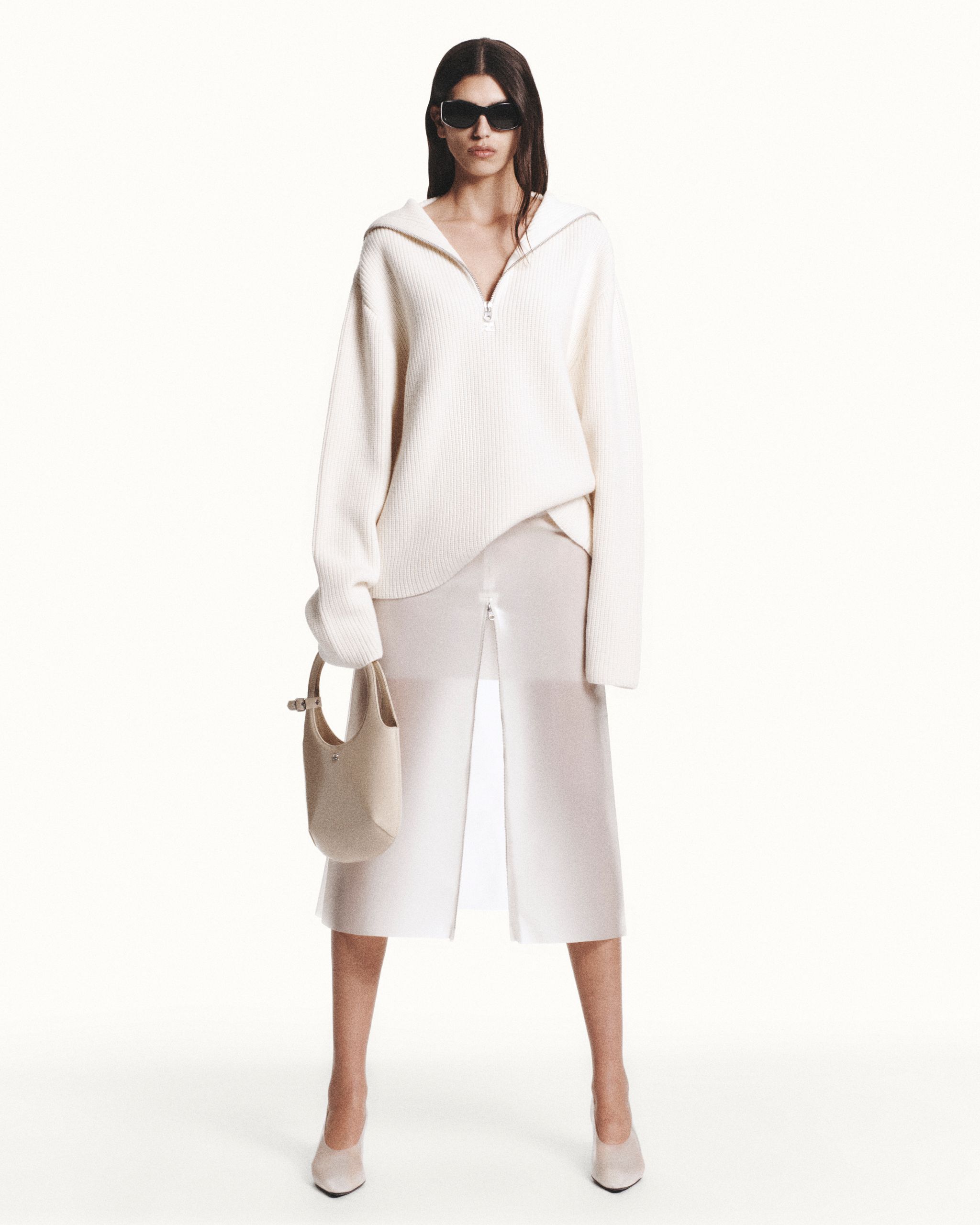 Elegant white knitted sweater and midi skirt with a front zipper, styled by Courrèges.