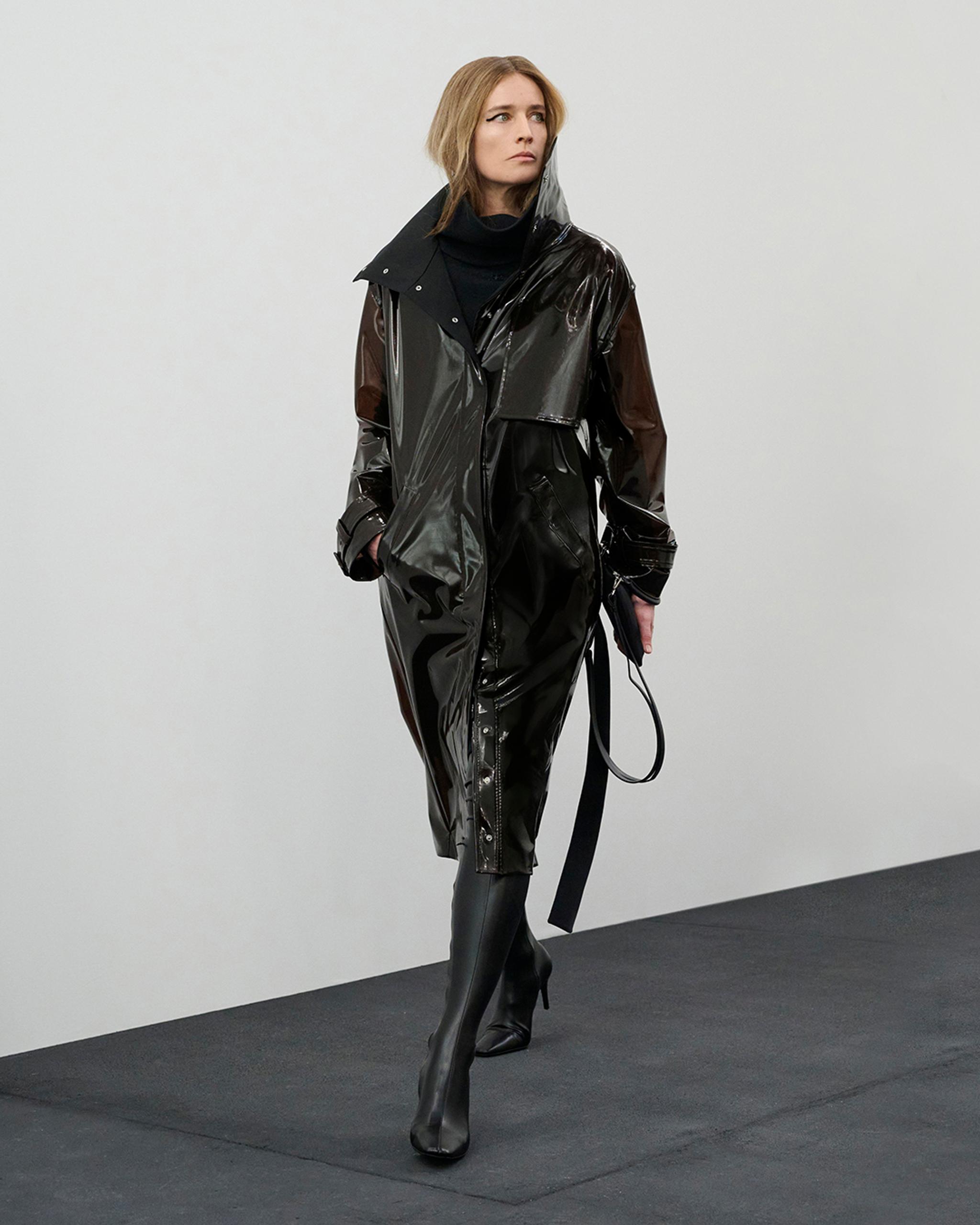Elegant black latex raincoat from Courrèges, perfect for a chic urban look.