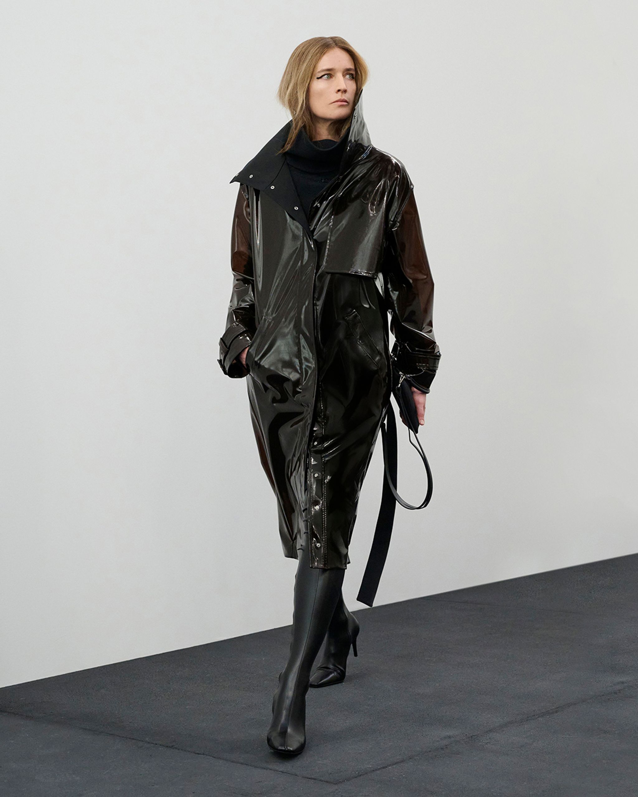 Imperméable en latex noir Courrèges, parfait pour un look urbain chic.
