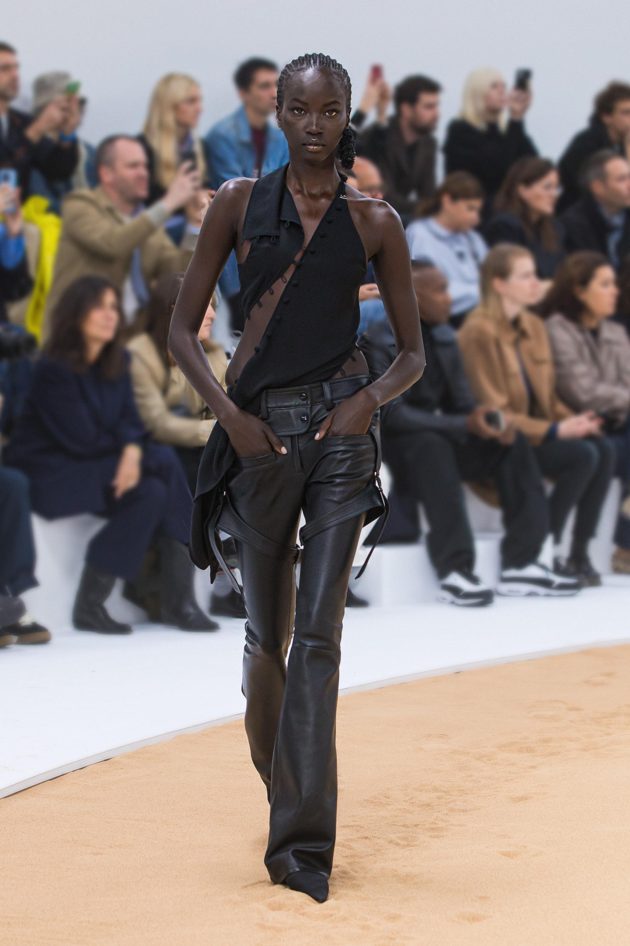 Tenue de mode élégante noire portée par un mannequin sur un podium pour Courrèges, site e-commerce.