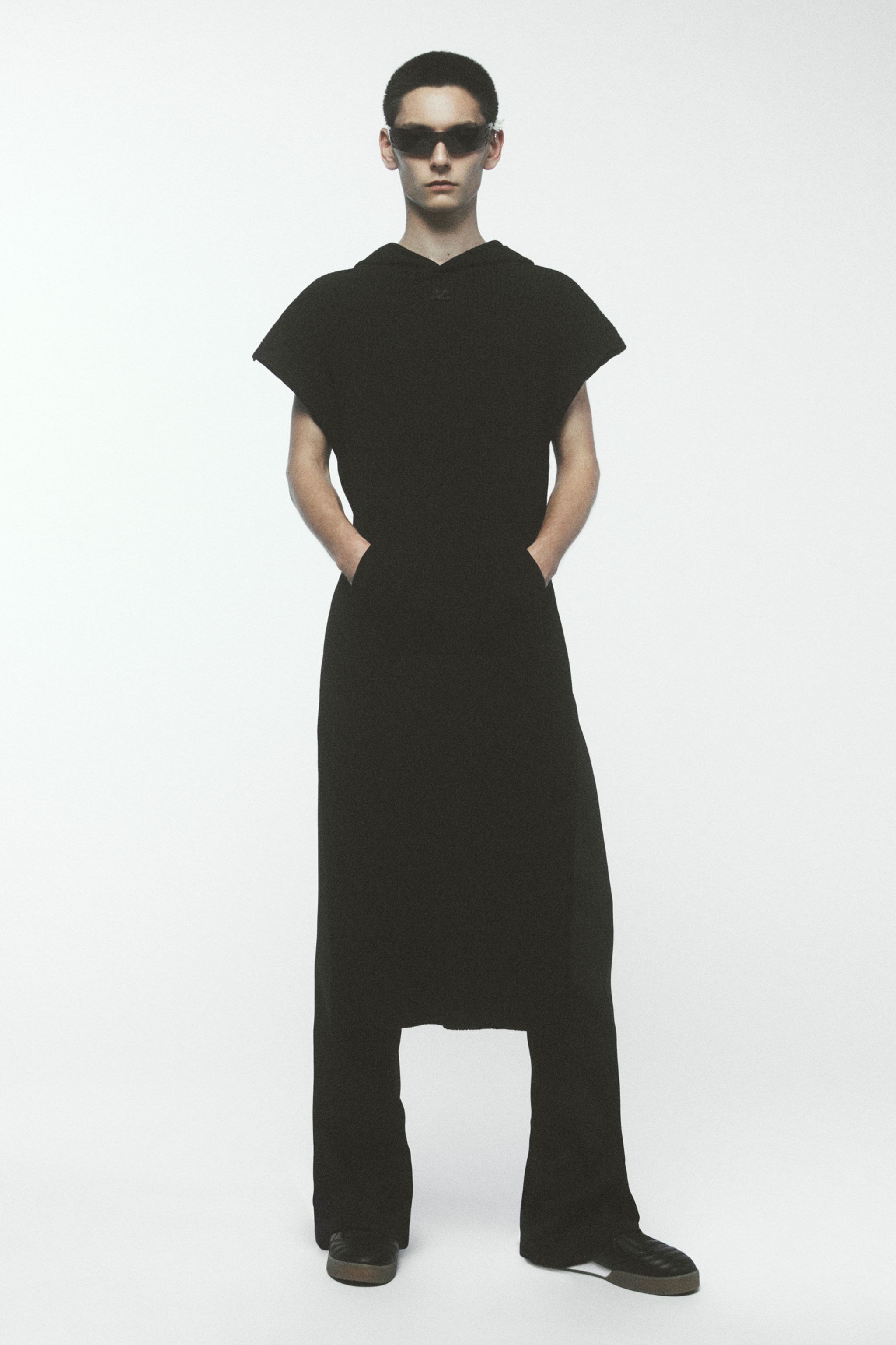 Elegant black modern fashion look by Courrèges featuring a long skirt and sunglasses.