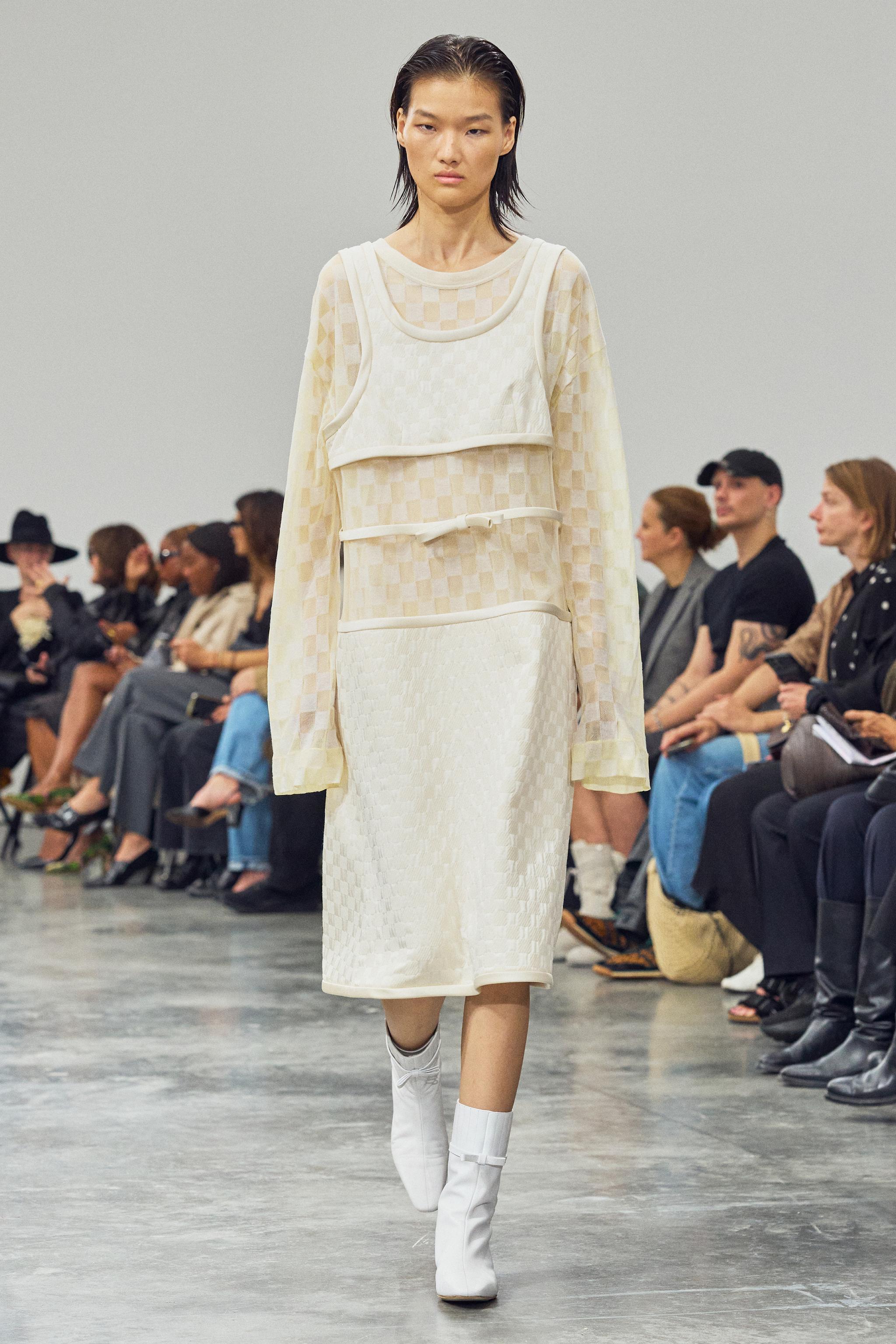 Elegant white designer outfit showcased on runway for Courrèges fashion brand website.