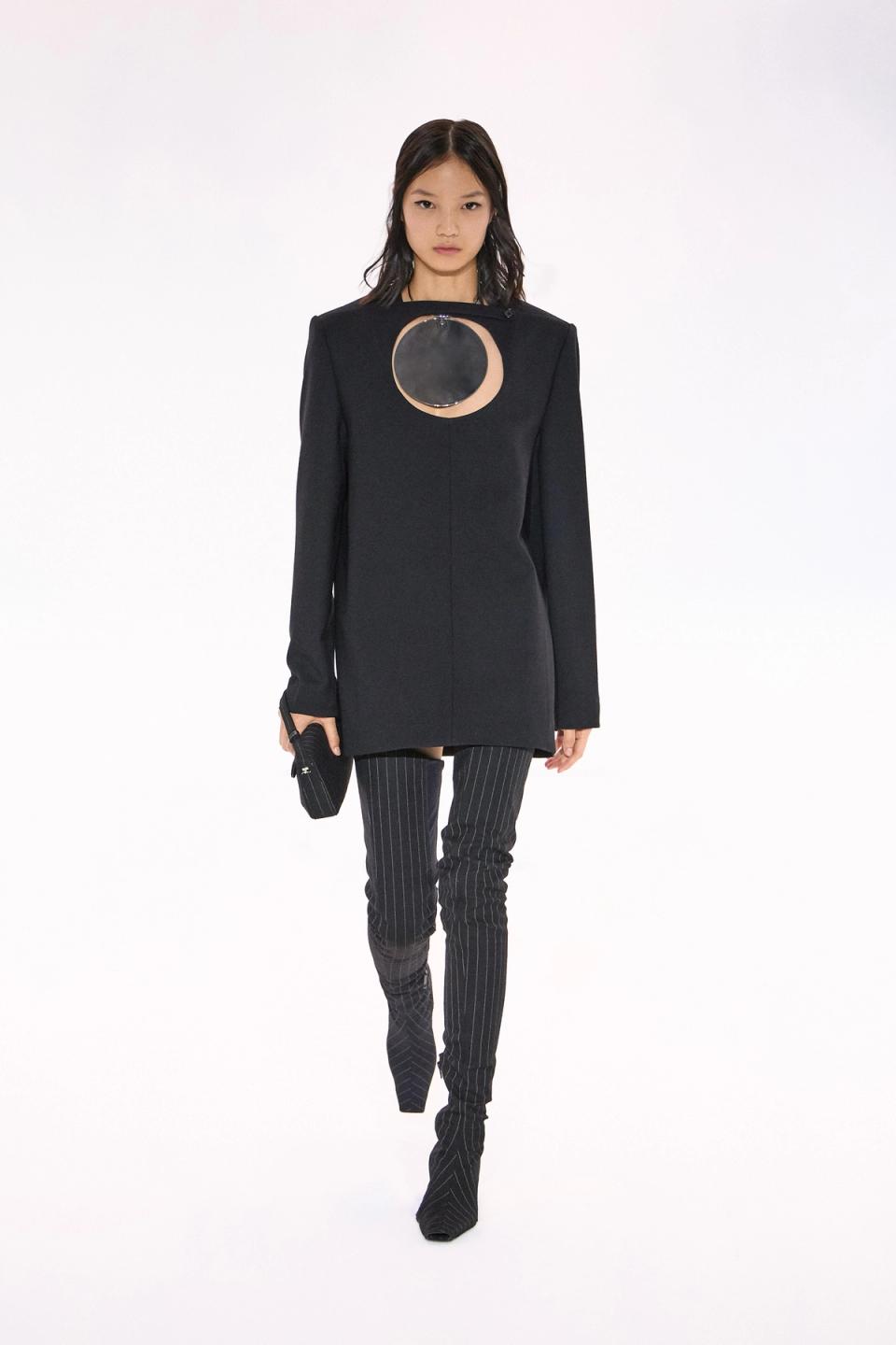 Elegant black Courrèges dress with futuristic round mirror cutouts and pinstripe pants.