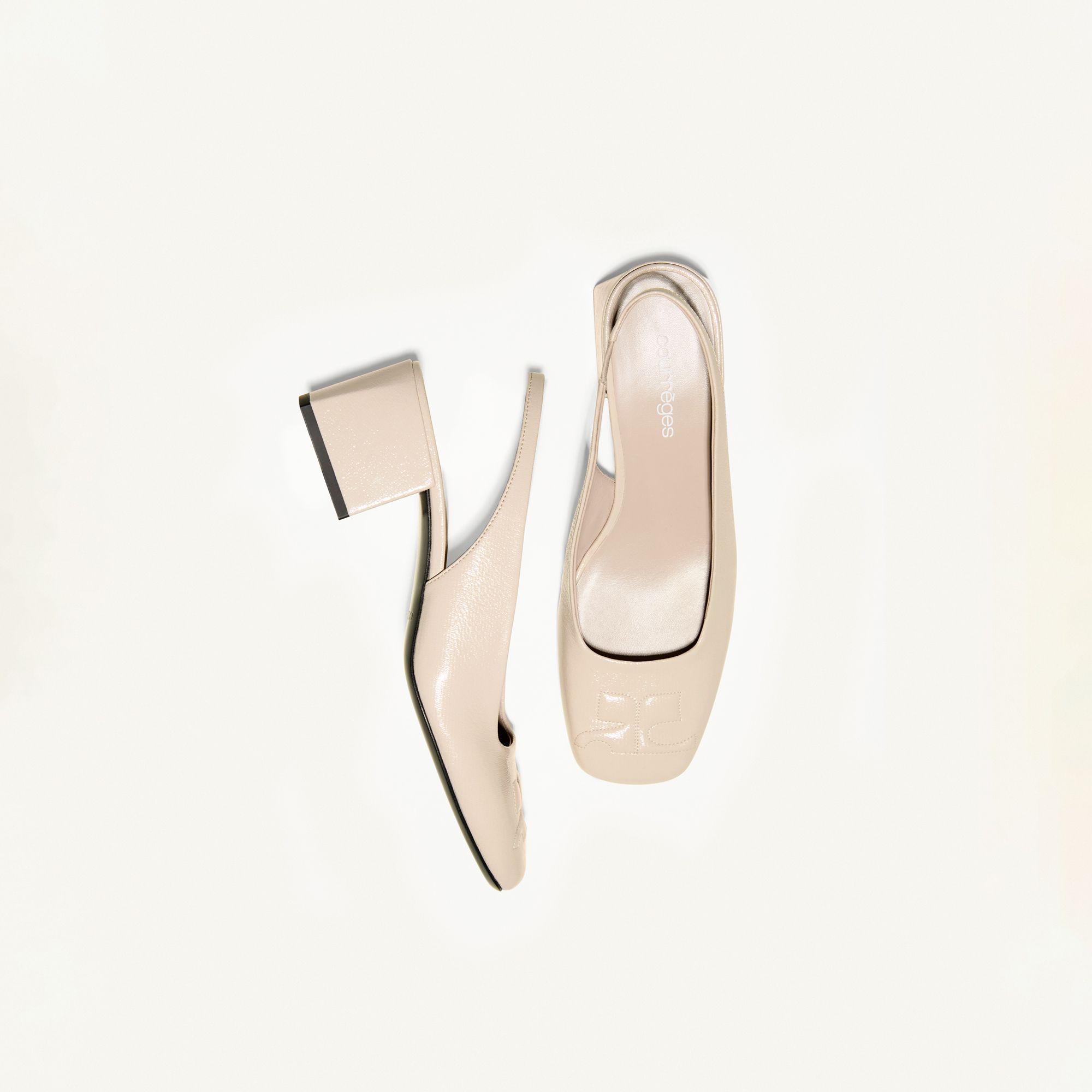 Elegant beige high-heeled shoes by Courrèges displayed on a white background for fashion retail.