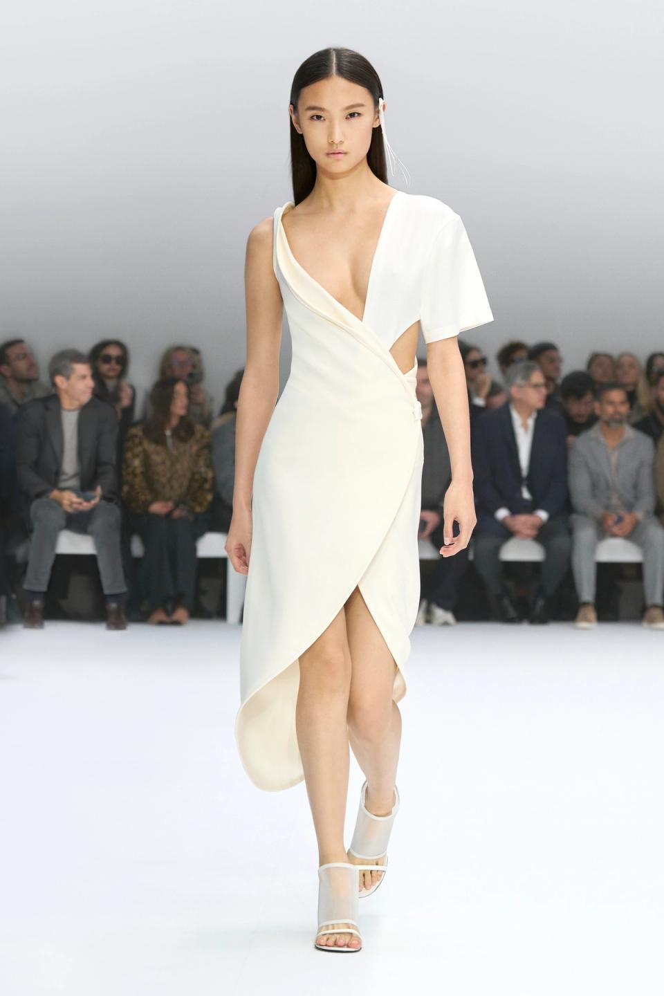 Elegant white dress by Courrèges showcased on a runway, perfect for modern fashion statements.