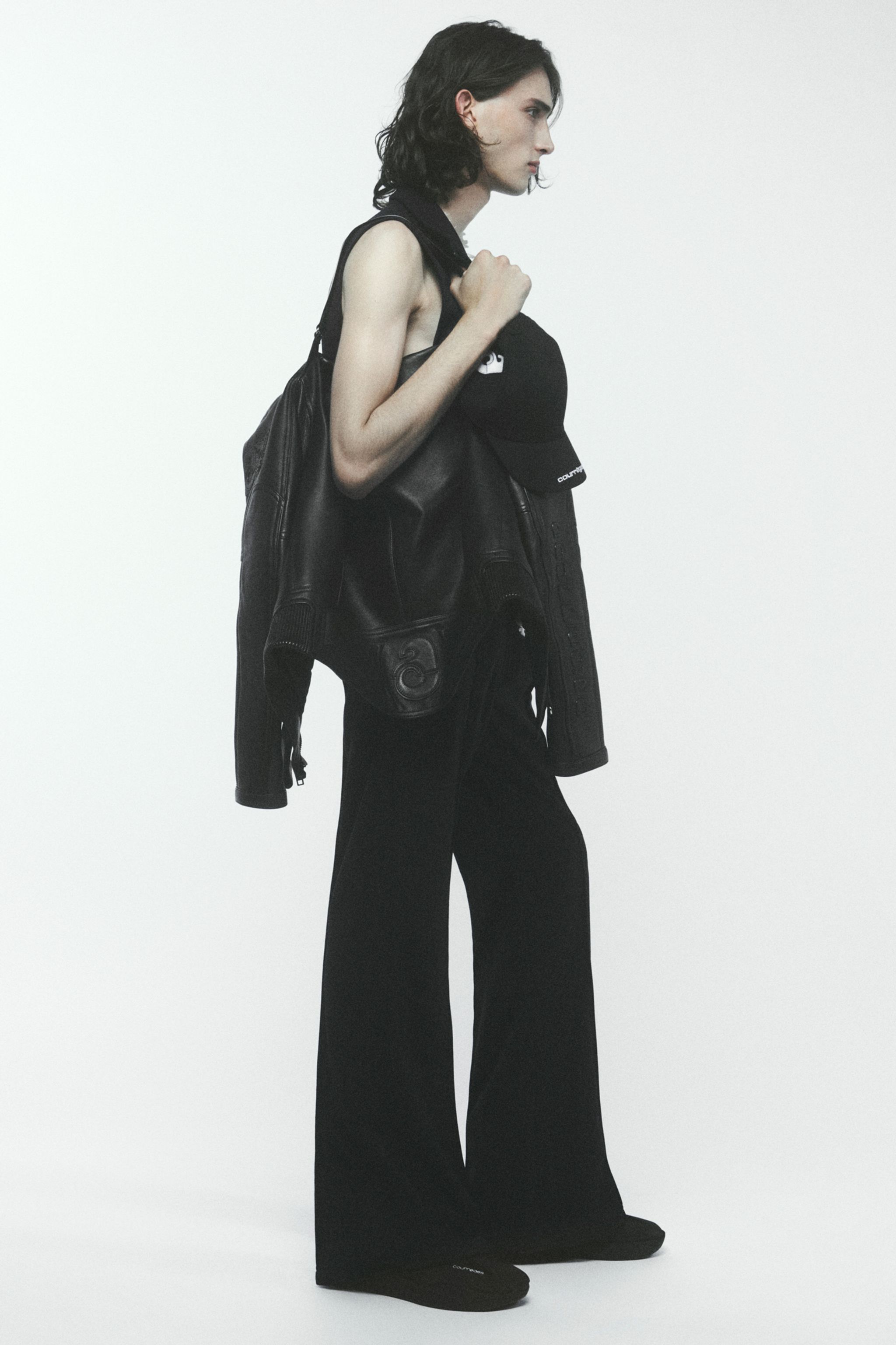 Elegant streetwear look with black leather jacket, wide-leg pants, and Courrèges accessories.