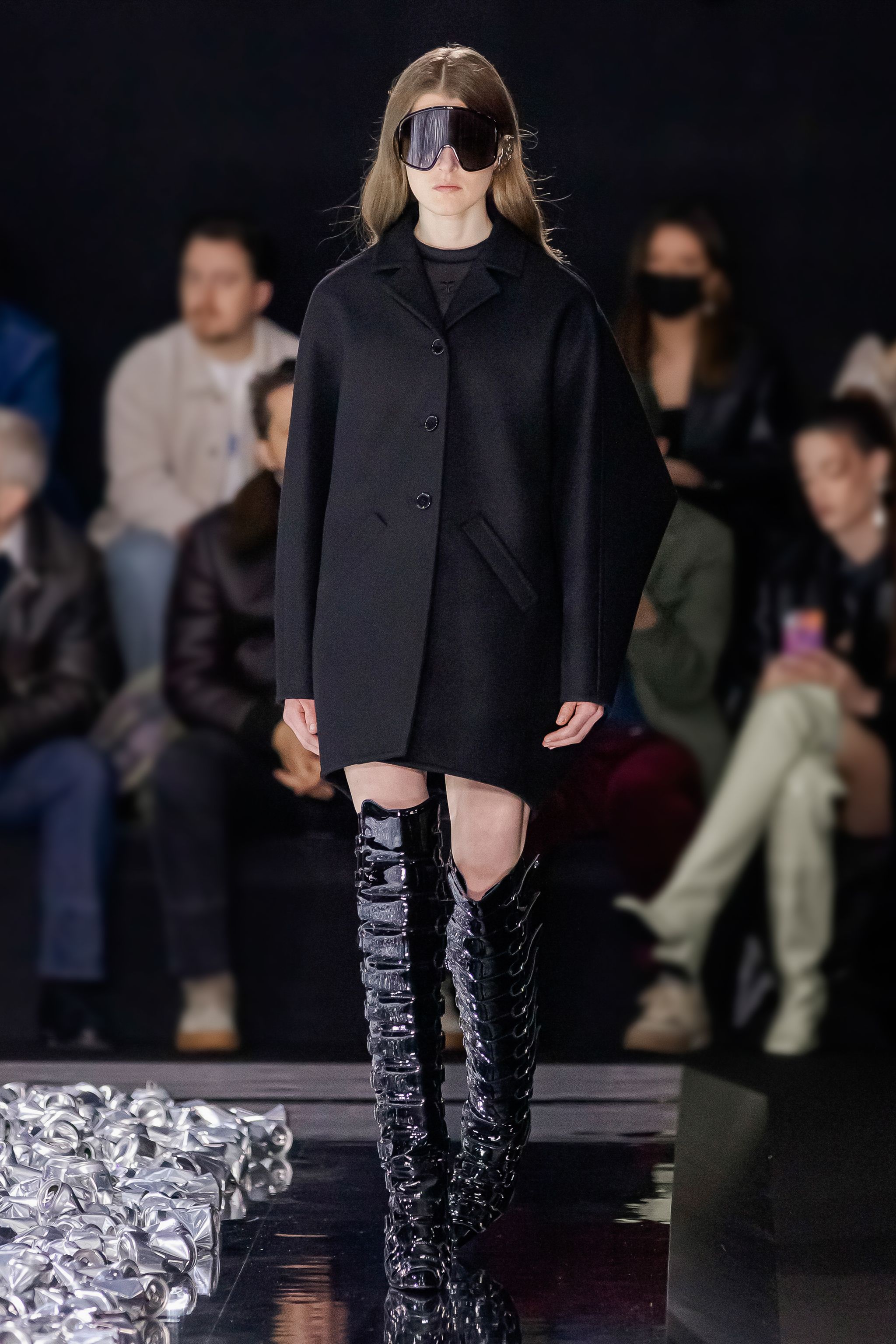 Sophisticated black coat and futuristic knee-high black boots on a fashion runway, Courrèges.