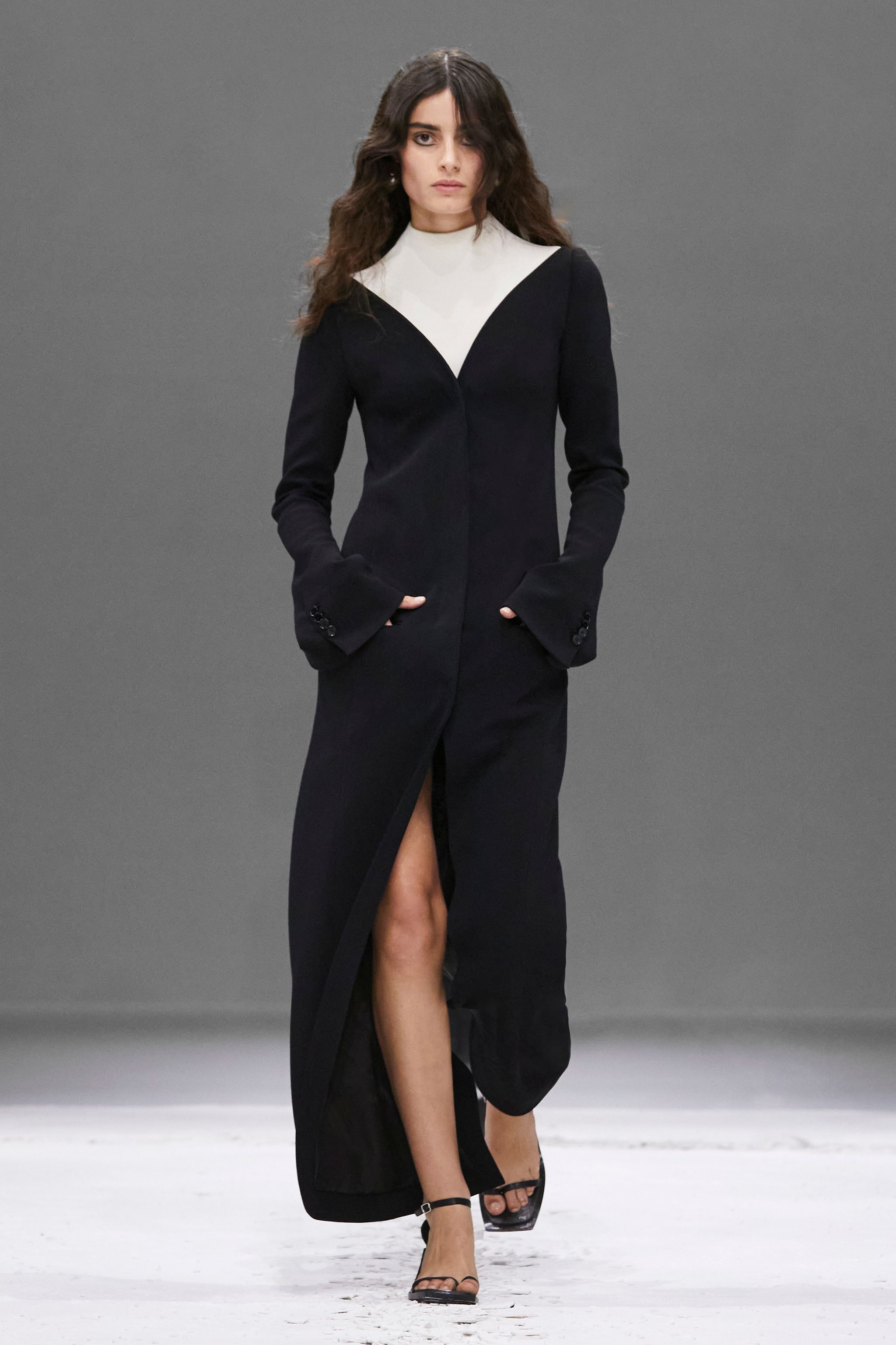 Elegant black long dress with white detail, featuring a high slit, ideal for Courrèges fashion.