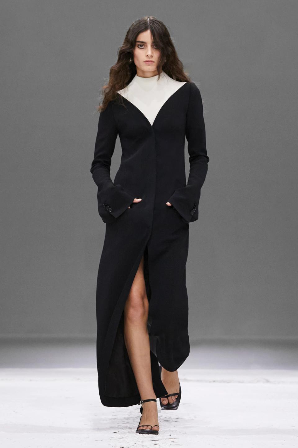Elegant black long dress with white detail, featuring a high slit, ideal for Courrèges fashion.