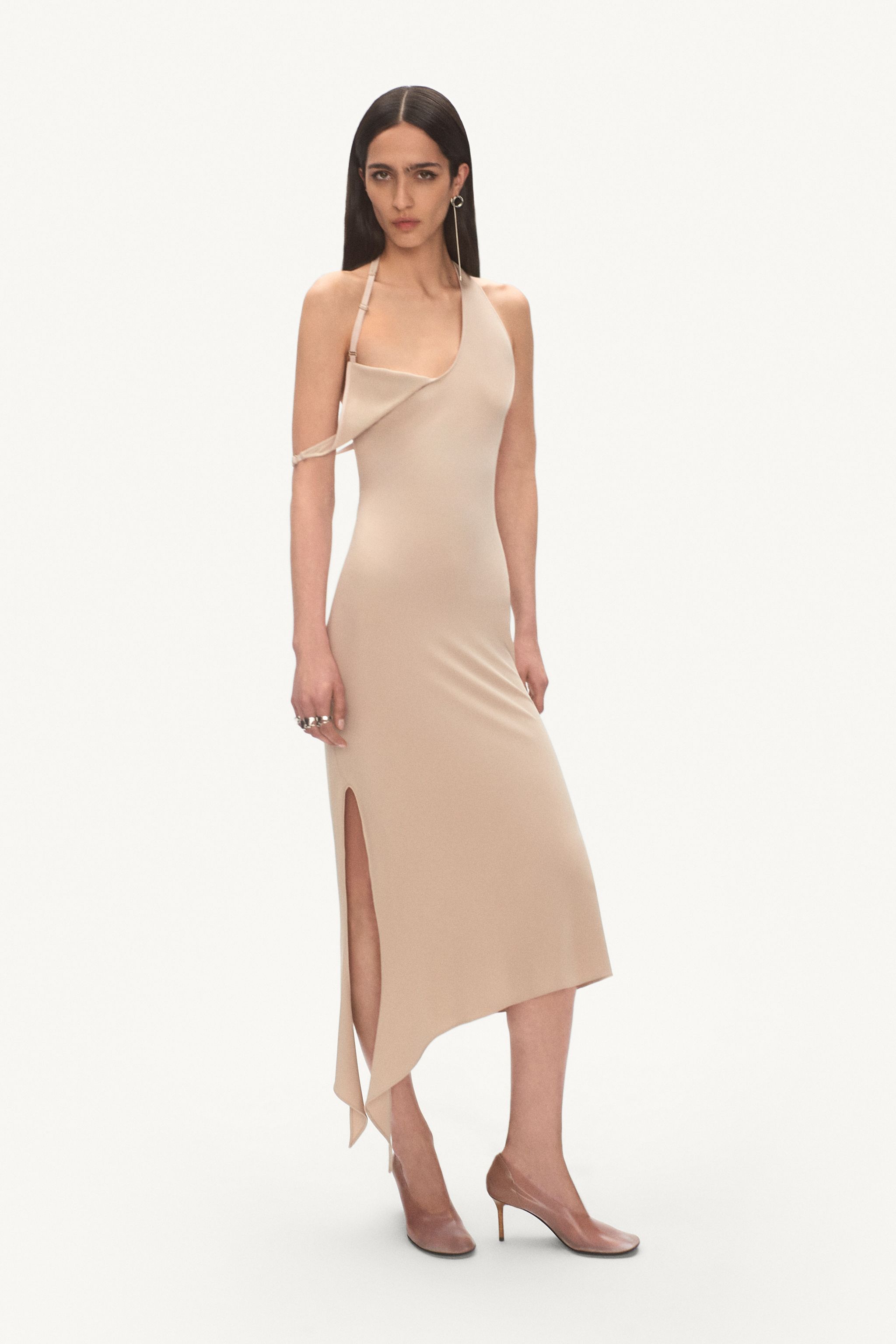 Elegant beige satin dress with asymmetric details and side slit, Courrèges fashion.