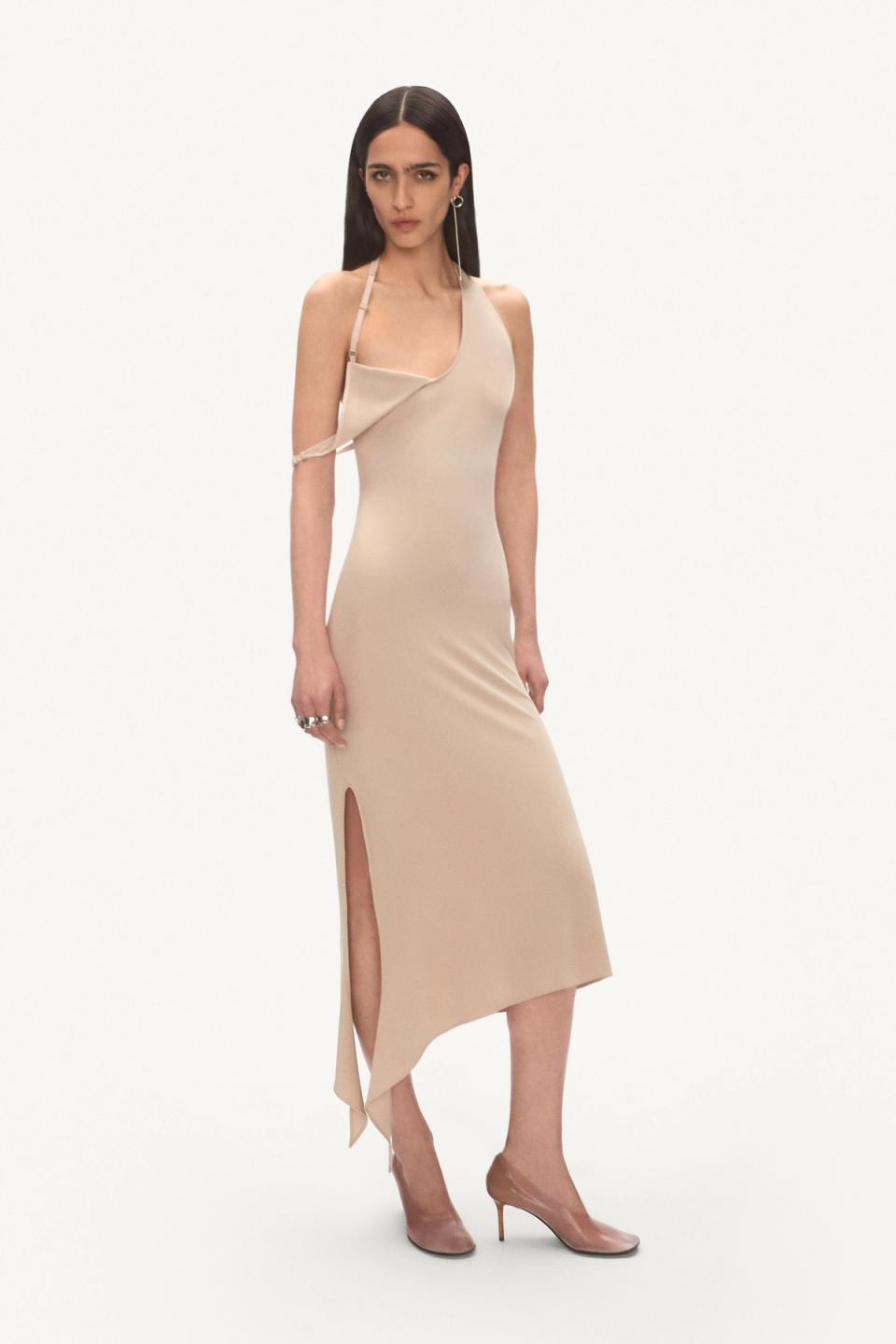 Elegant beige satin dress with asymmetric details and side slit, Courrèges fashion.