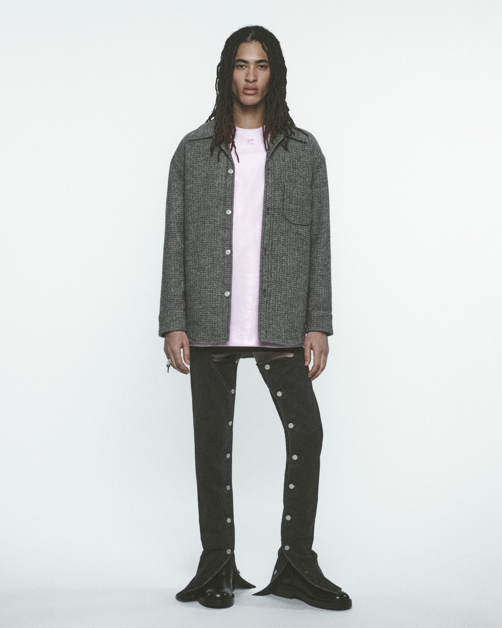 Mannequin élégant portant des vêtements Courrèges, présenté sur un fond minimaliste pour le commerce en ligne.