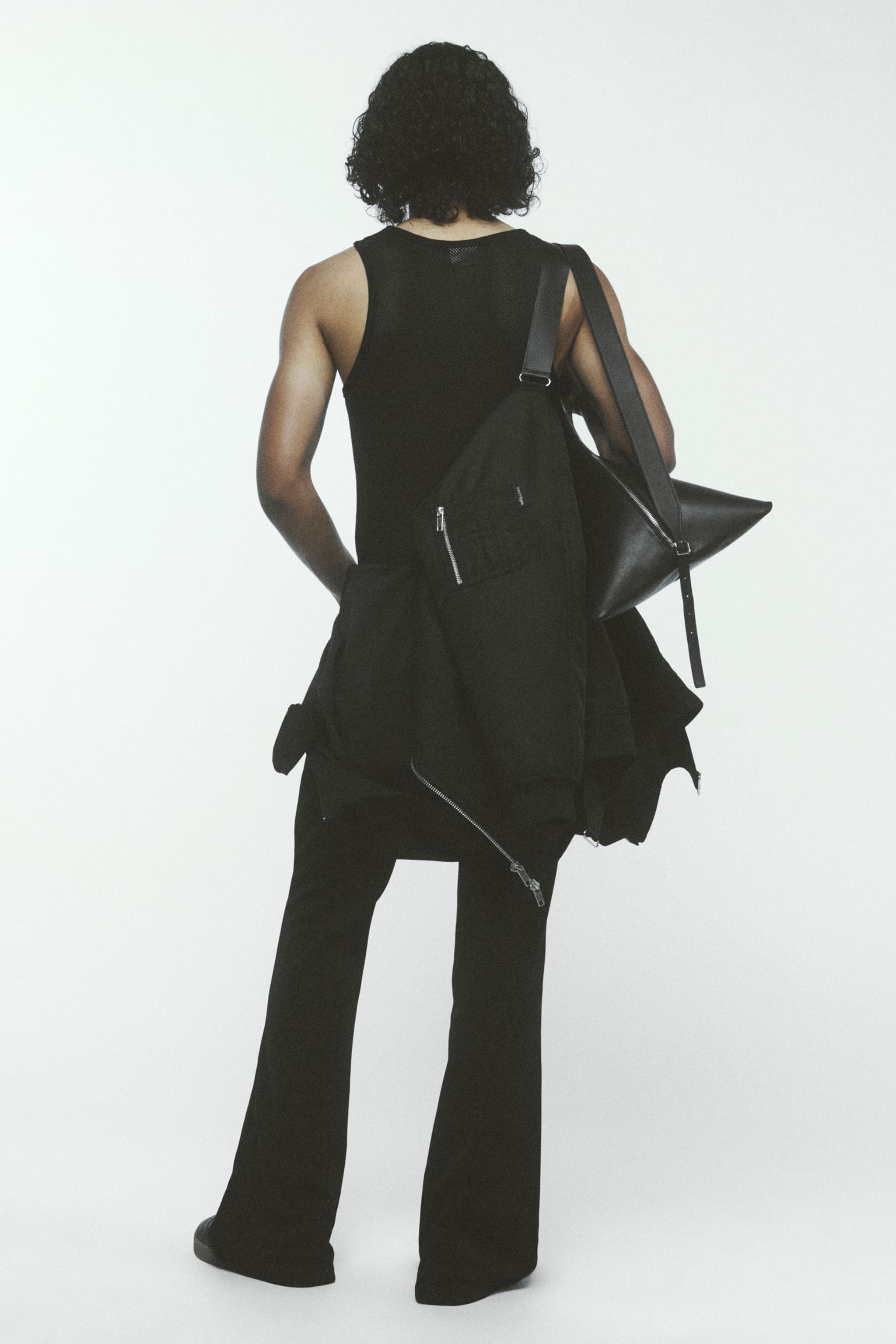 Elegant black fashion ensemble with stylish bags, representing Courrèges style on an ecommerce site.