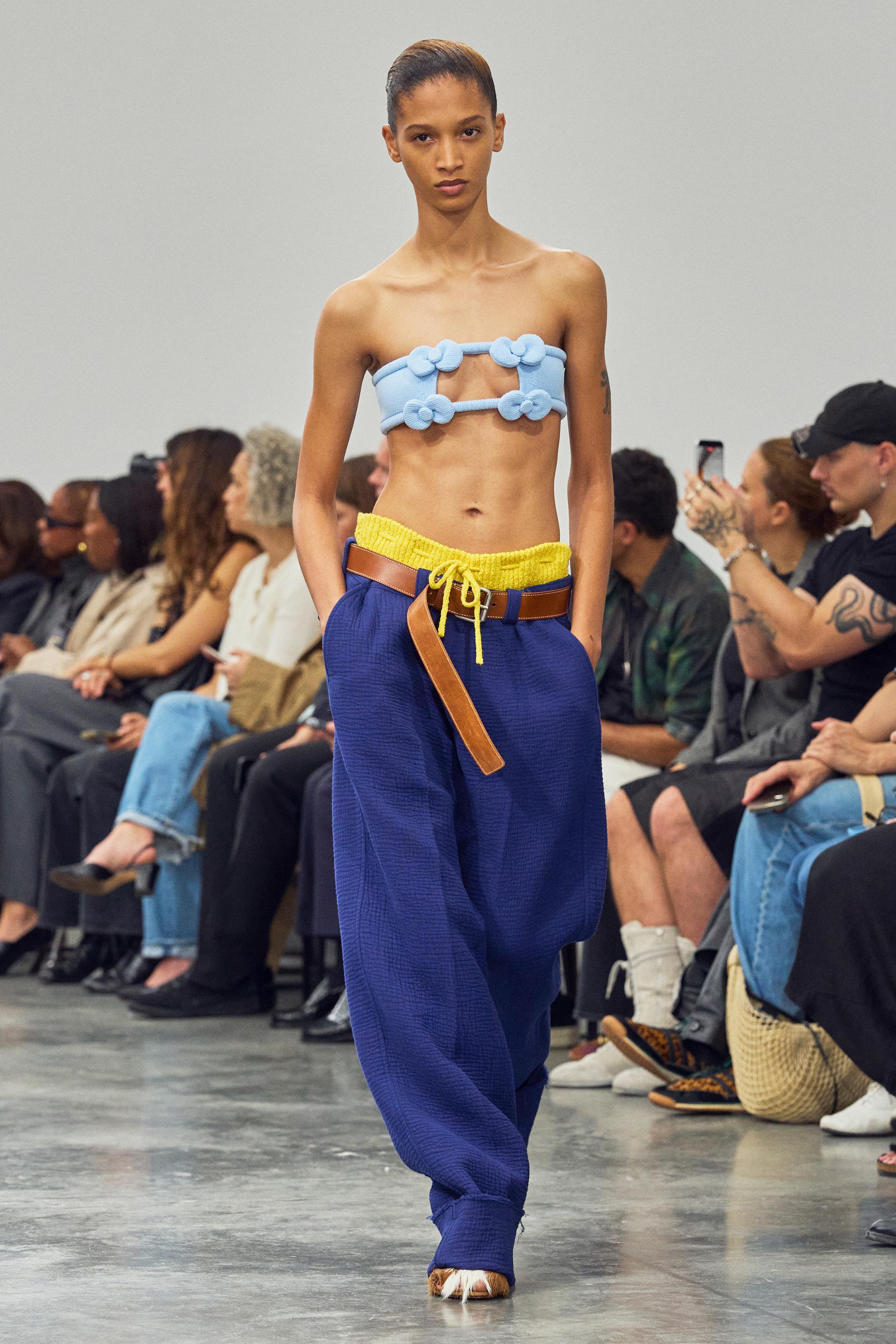 Elegant runway fashion by Courrèges featuring a unique knit crop top and loose pants.