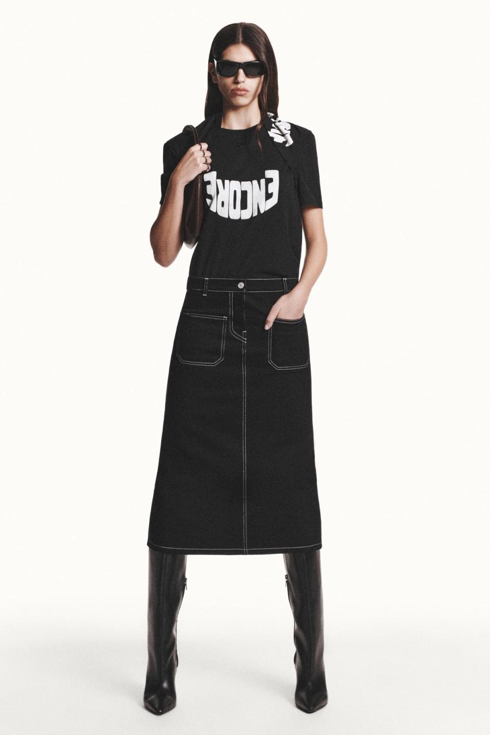 Chic streetwear look with black graphic T-shirt, long denim skirt, and accessories from Courrèges.