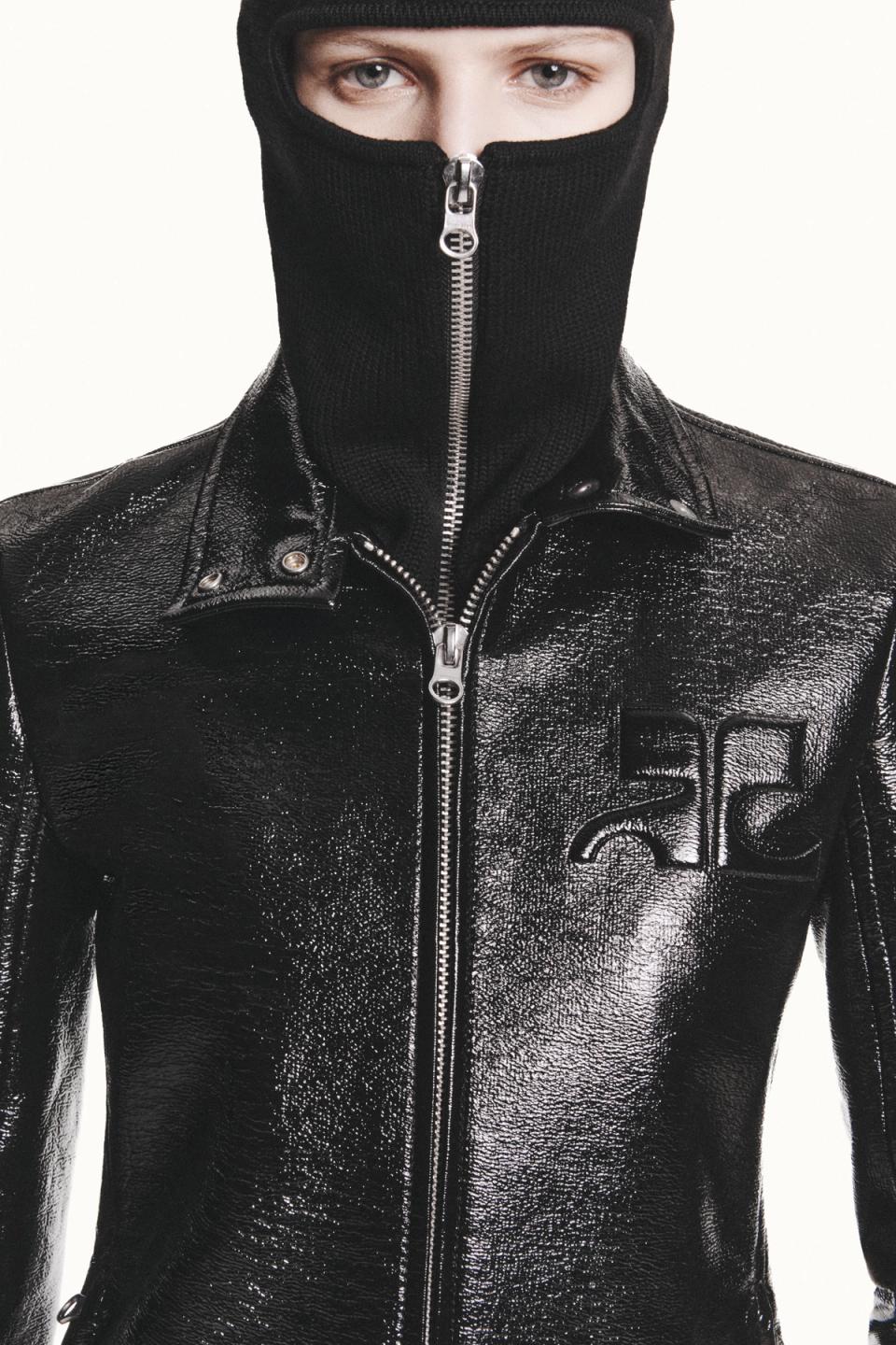 Elegant black shiny leather jacket with zipper and high-neck covering, Courrèges fashion.