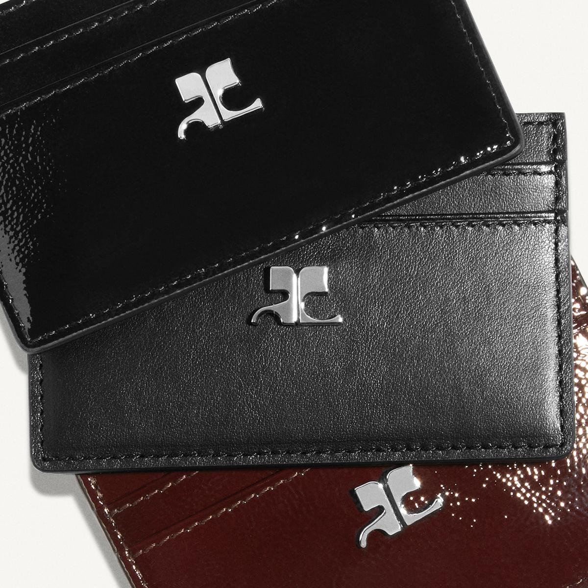 Elegant black and red leather wallets with Courrèges logo, perfect for fashion accessories.