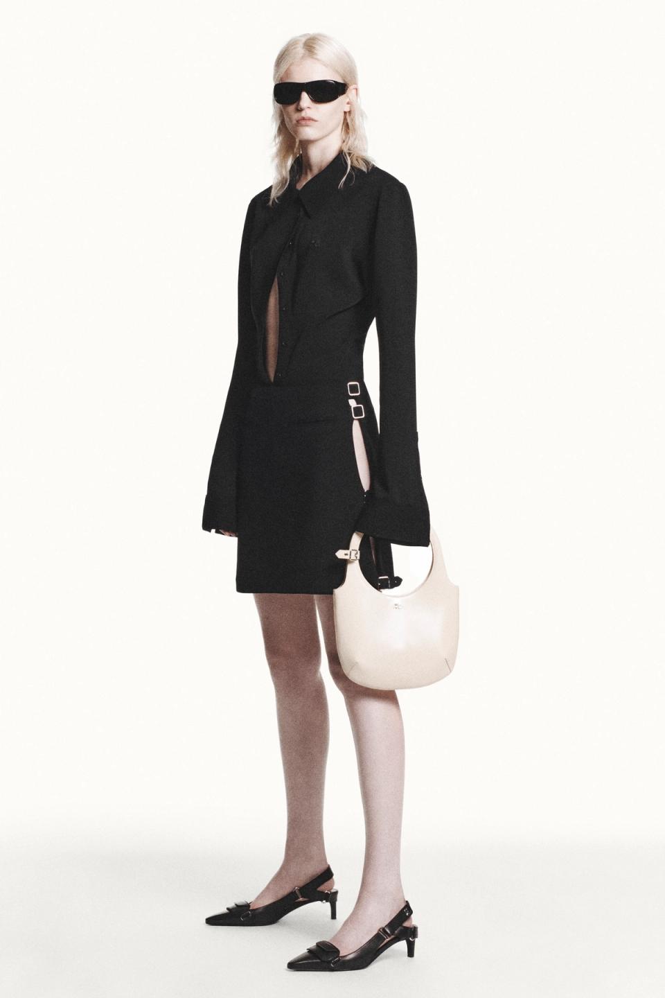 Elegant black Courrèges dress with cut-outs, paired with stylish accessories on a fashion model.