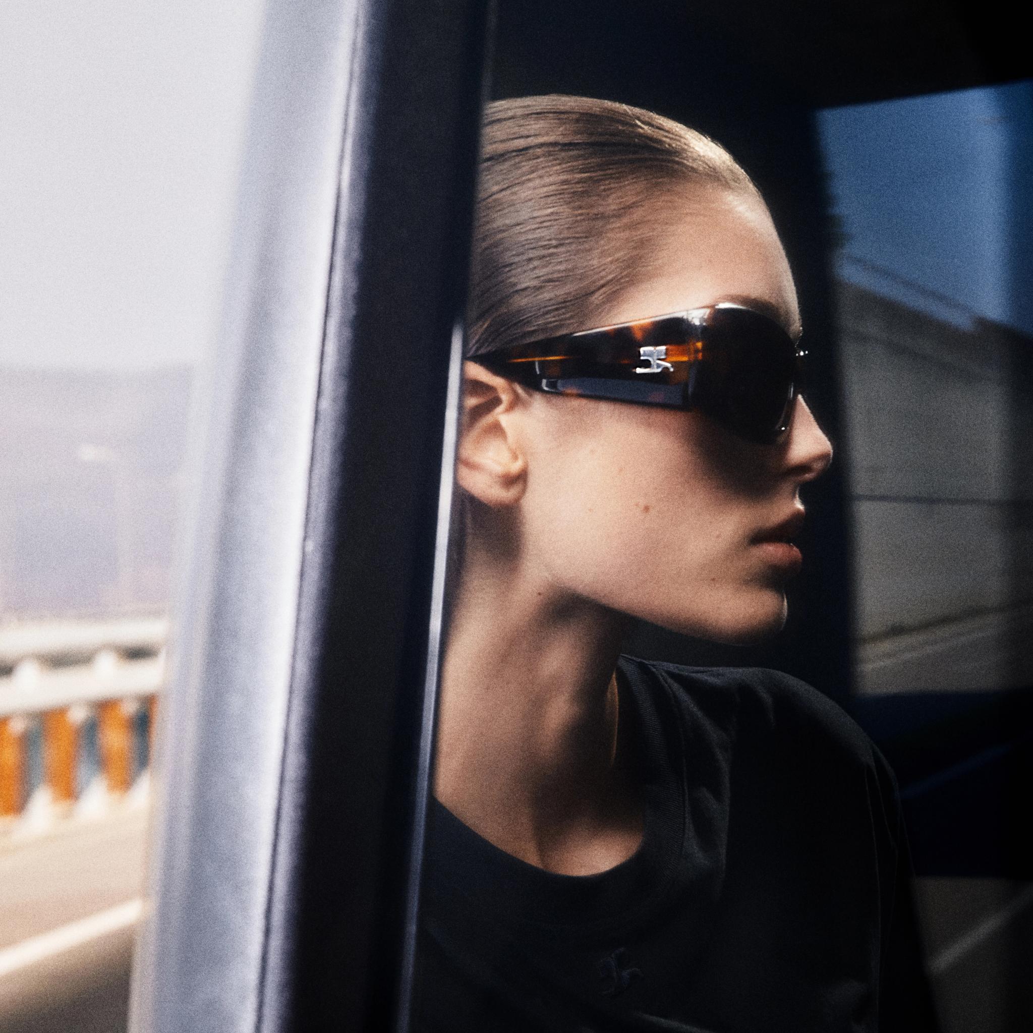 Elegant woman wearing Courrèges sunglasses, showcasing contemporary fashion for eCommerce.