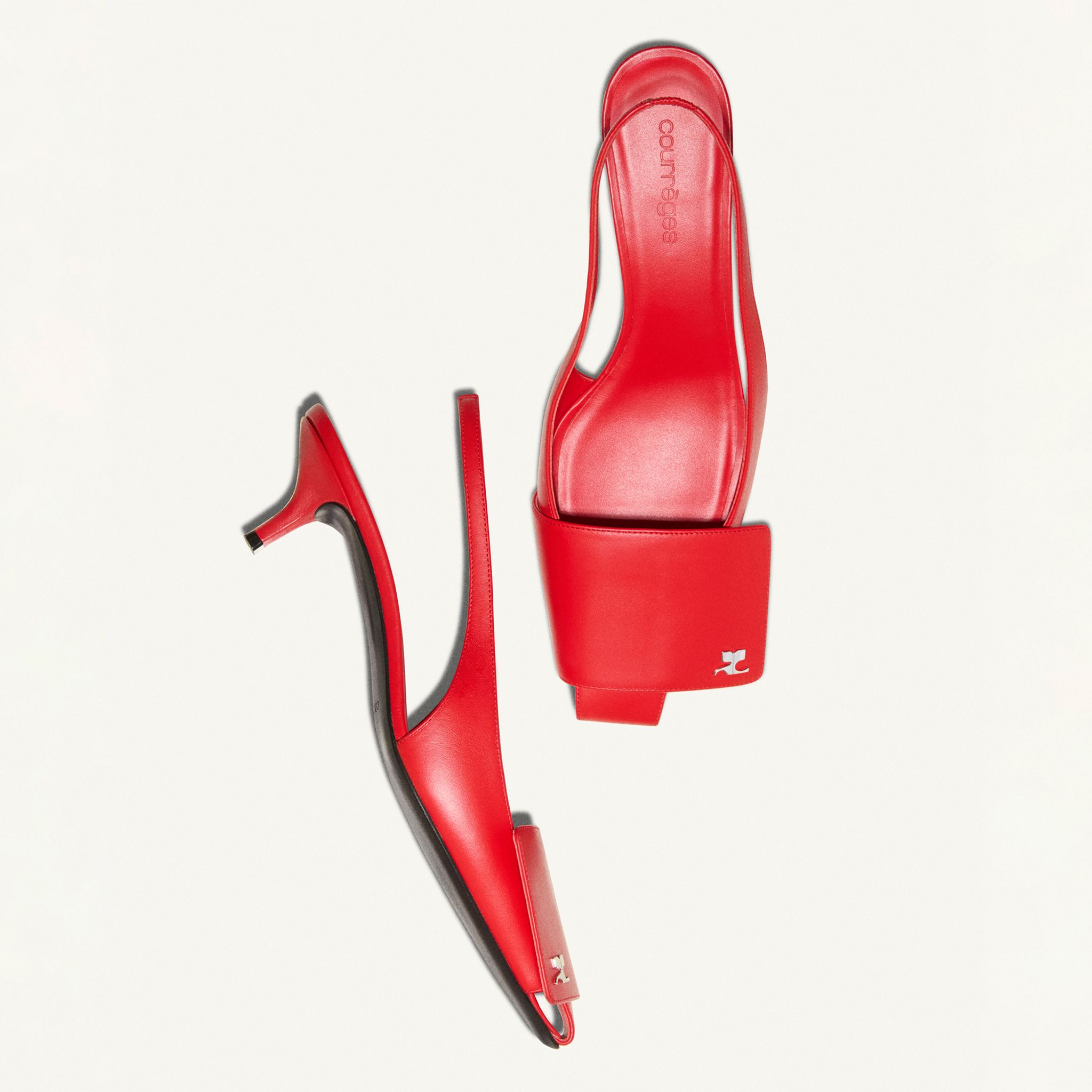 Elegant red Courrèges high-heeled mules with a strap, showcased on a white background.