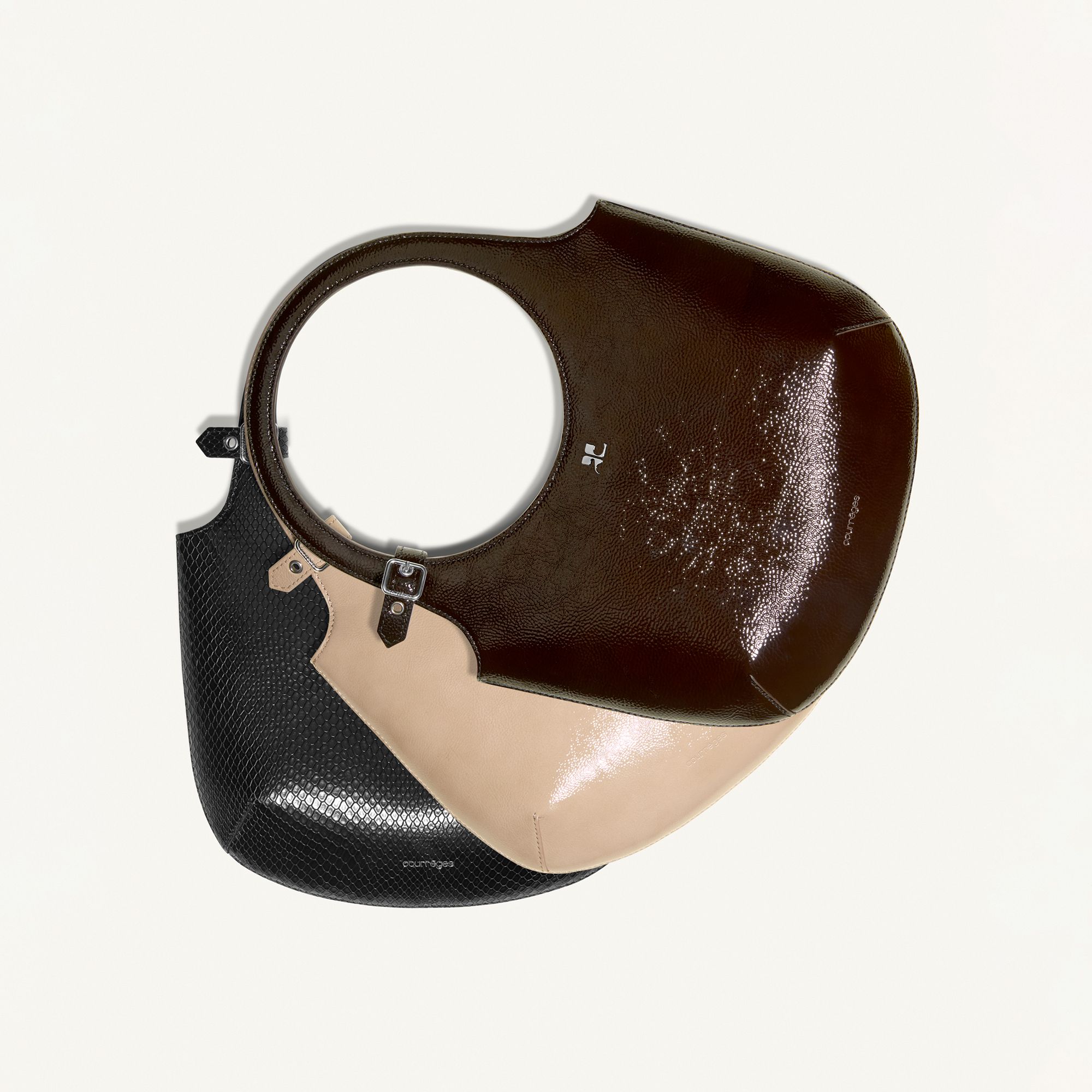 Elegant Courrèges handbag with a modern mix of black, beige, and brown leather on an ecommerce site.