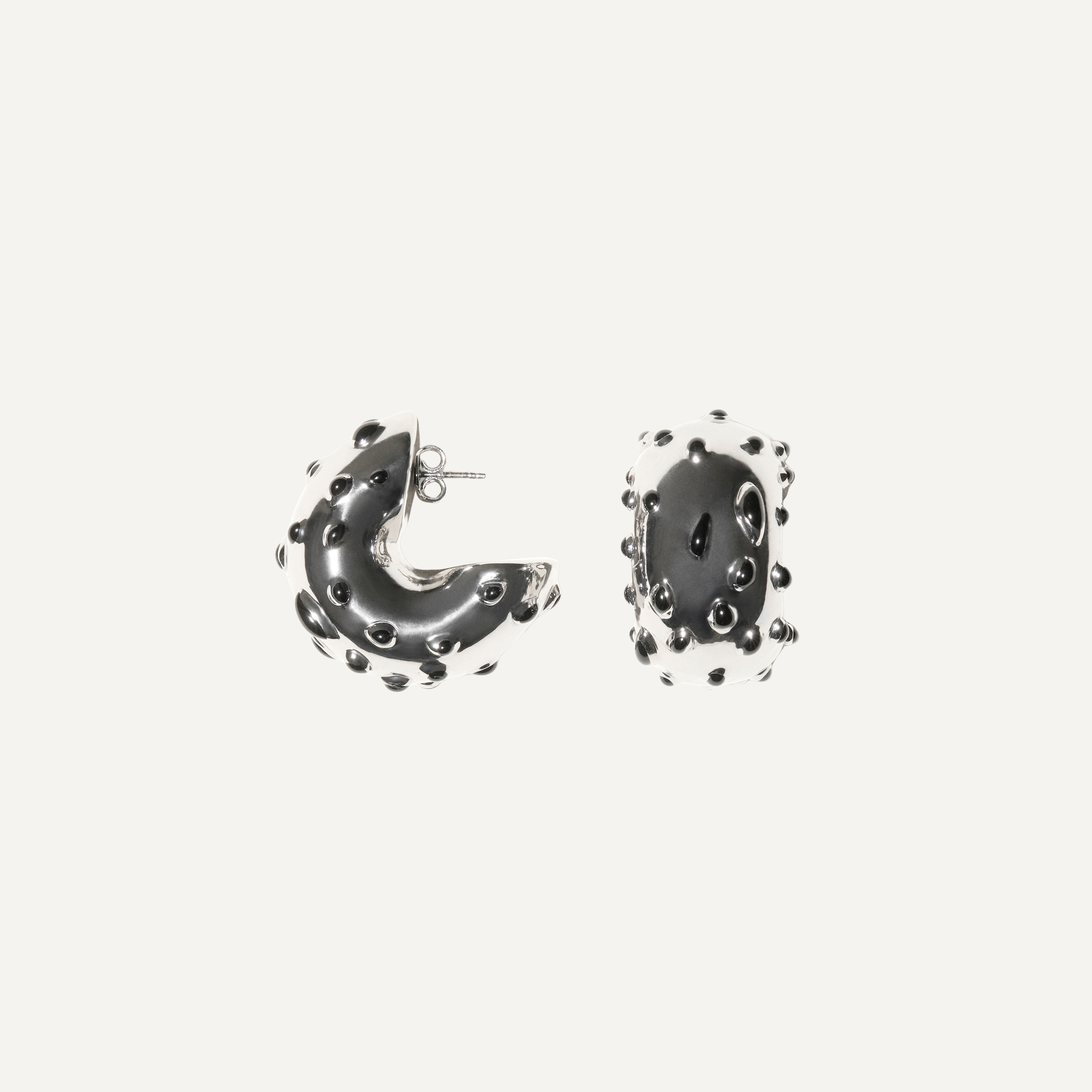 Elegant black and white hoop earrings with protective resin dots, Courrèges designer jewelry.