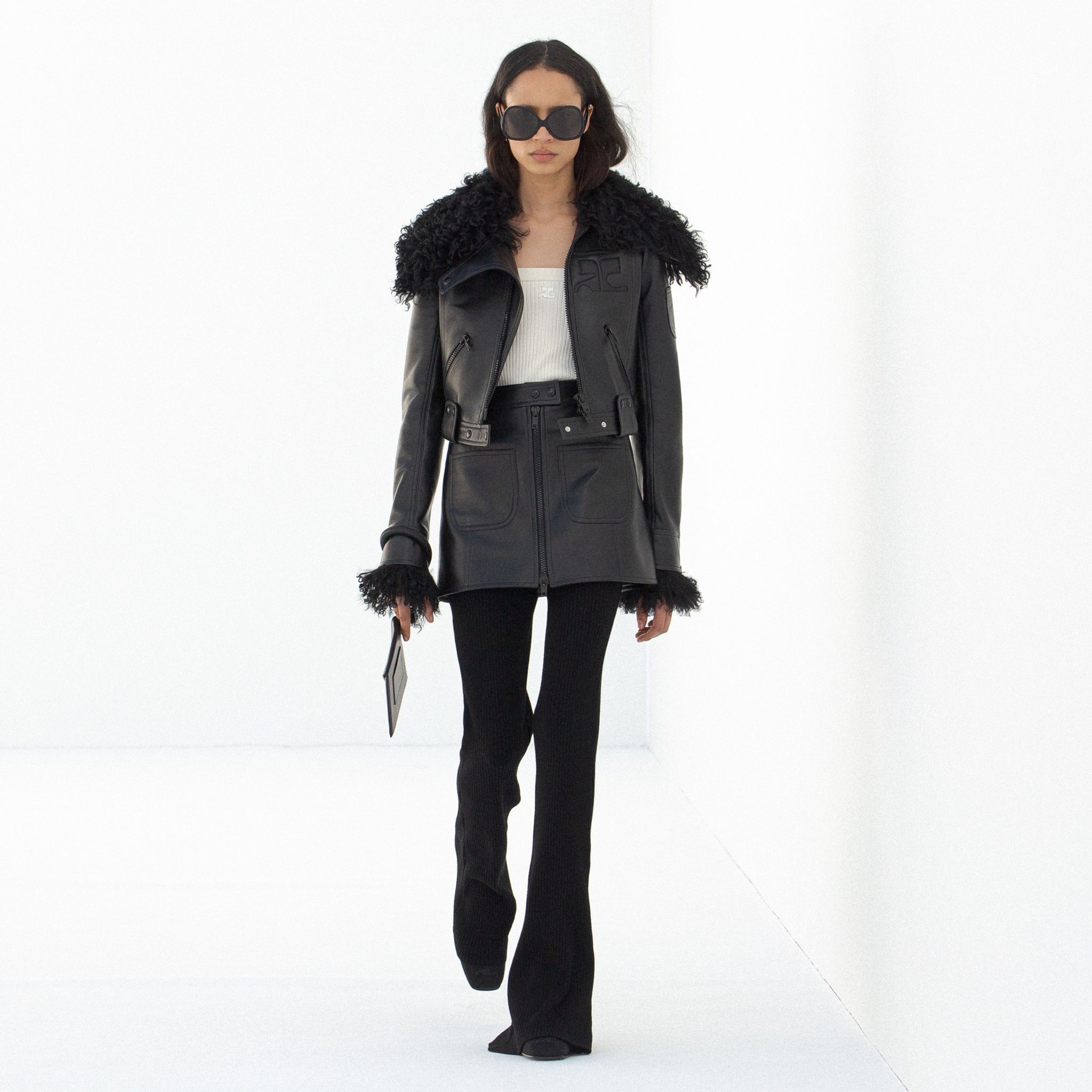 Elegant black leather jacket with fur accents, part of Courrèges' high-fashion collection.