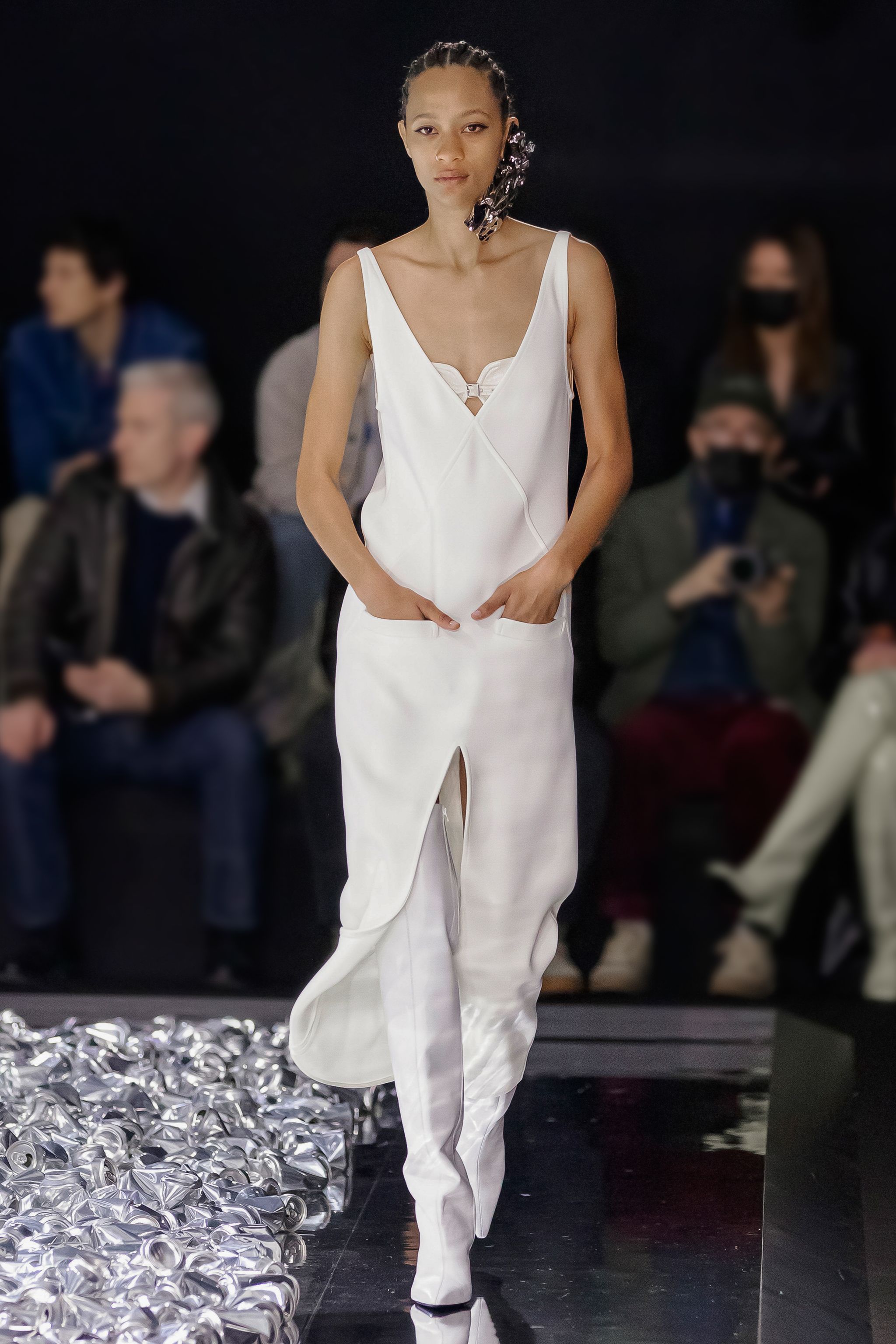 Elegant white dress with cut-outs, showcased on the Courrèges runway at a fashion event.