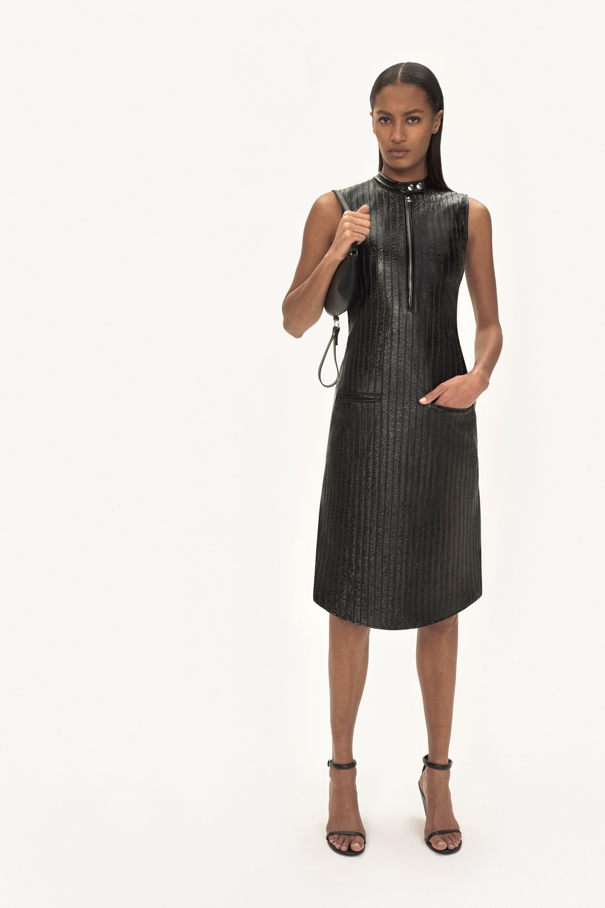 Elegant black leather dress with a high collar, zip front, and sleek straight silhouette for Courrèges.
