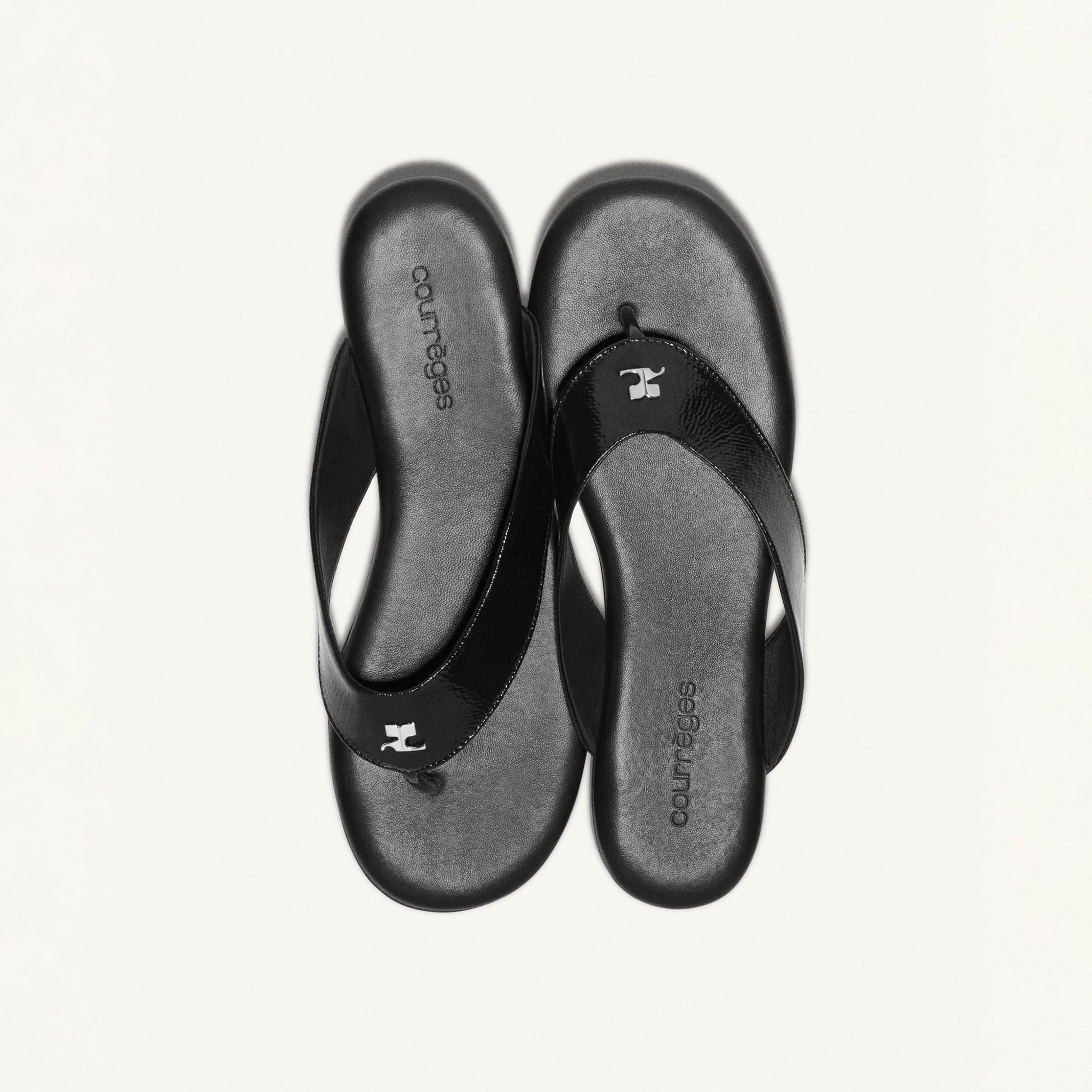 Sandales noires élégantes Courrèges pour une allure chic sur un site e-commerce.