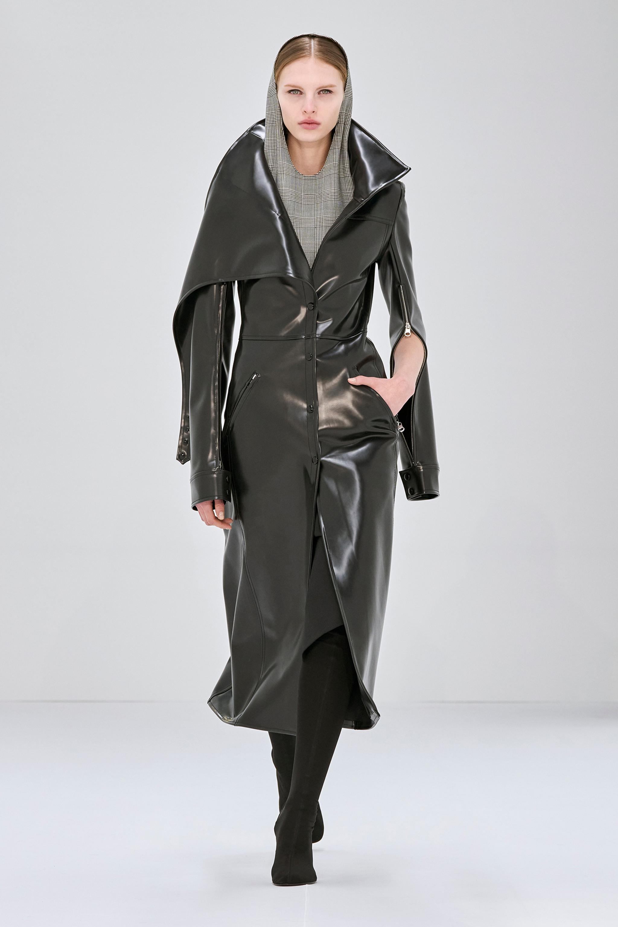 Manteau trench en cuir noir élégant avec capuche, signé Courrèges pour une touche mode moderne.