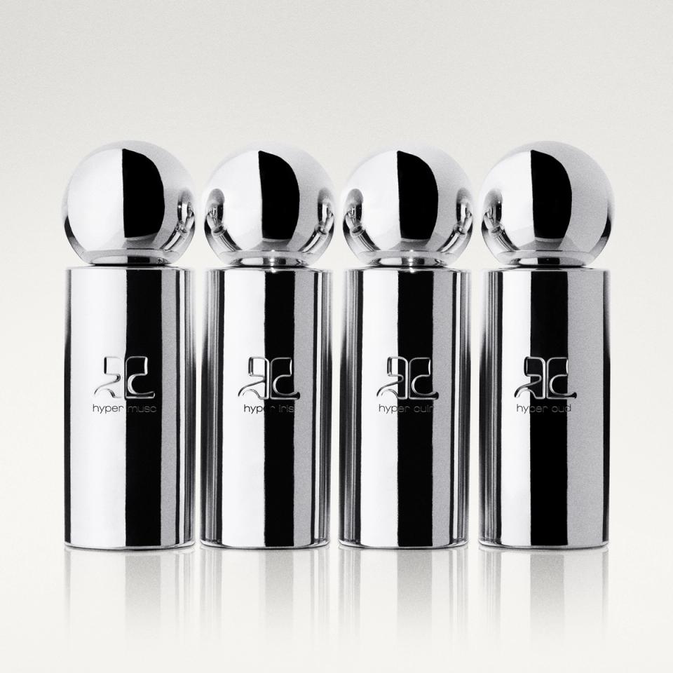 Four minimalist silver perfume bottles with spherical caps and Courrèges logo on a smooth background.