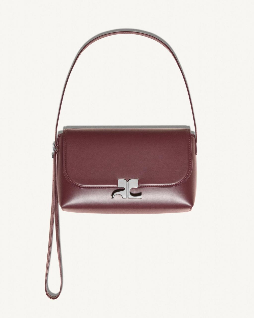 Sac à main maroon élégant de Courrèges avec design épuré sur fond blanc.