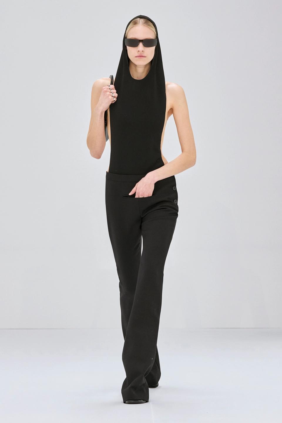 Elegant black sleeveless jumpsuit with hood and sunglasses, showcasing Courrèges fashion.
