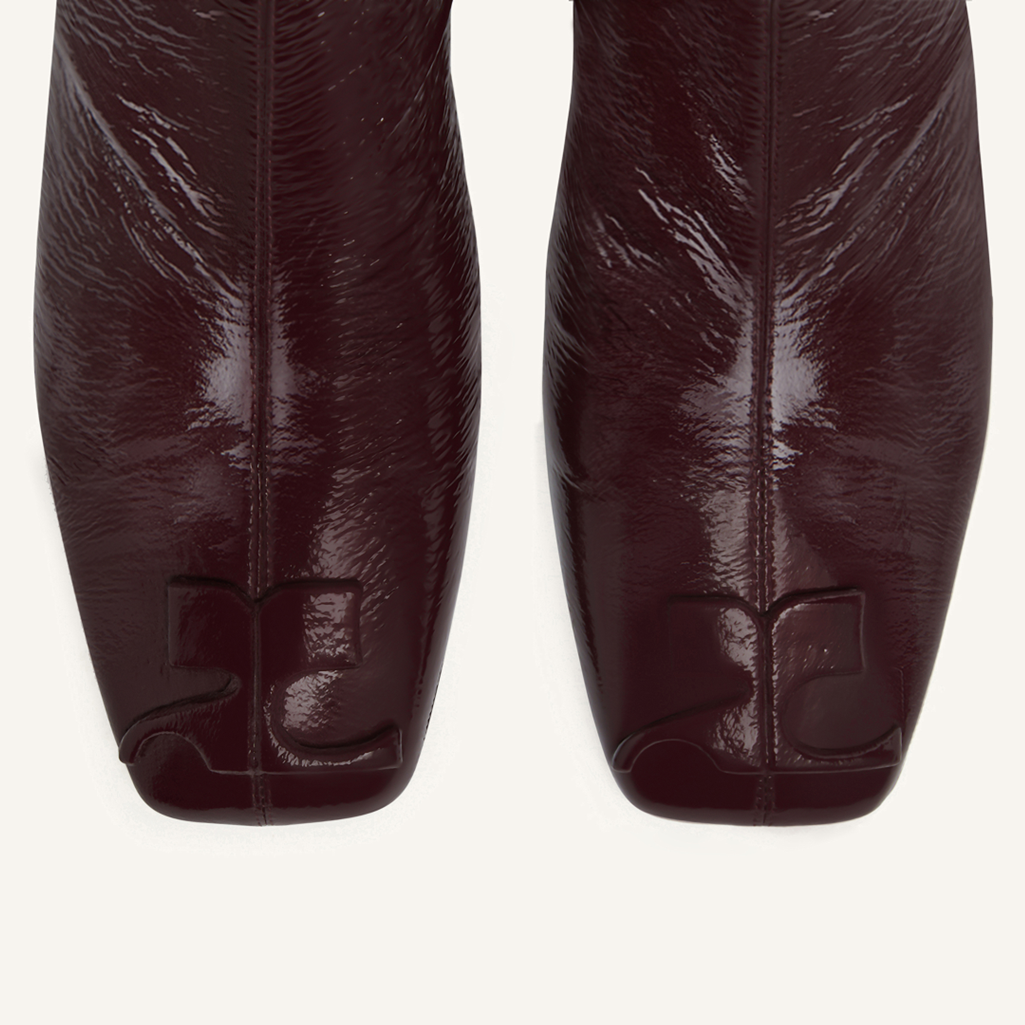 Elegant burgundy patent leather boots by Courrèges, showcasing modern style for fashion lovers.