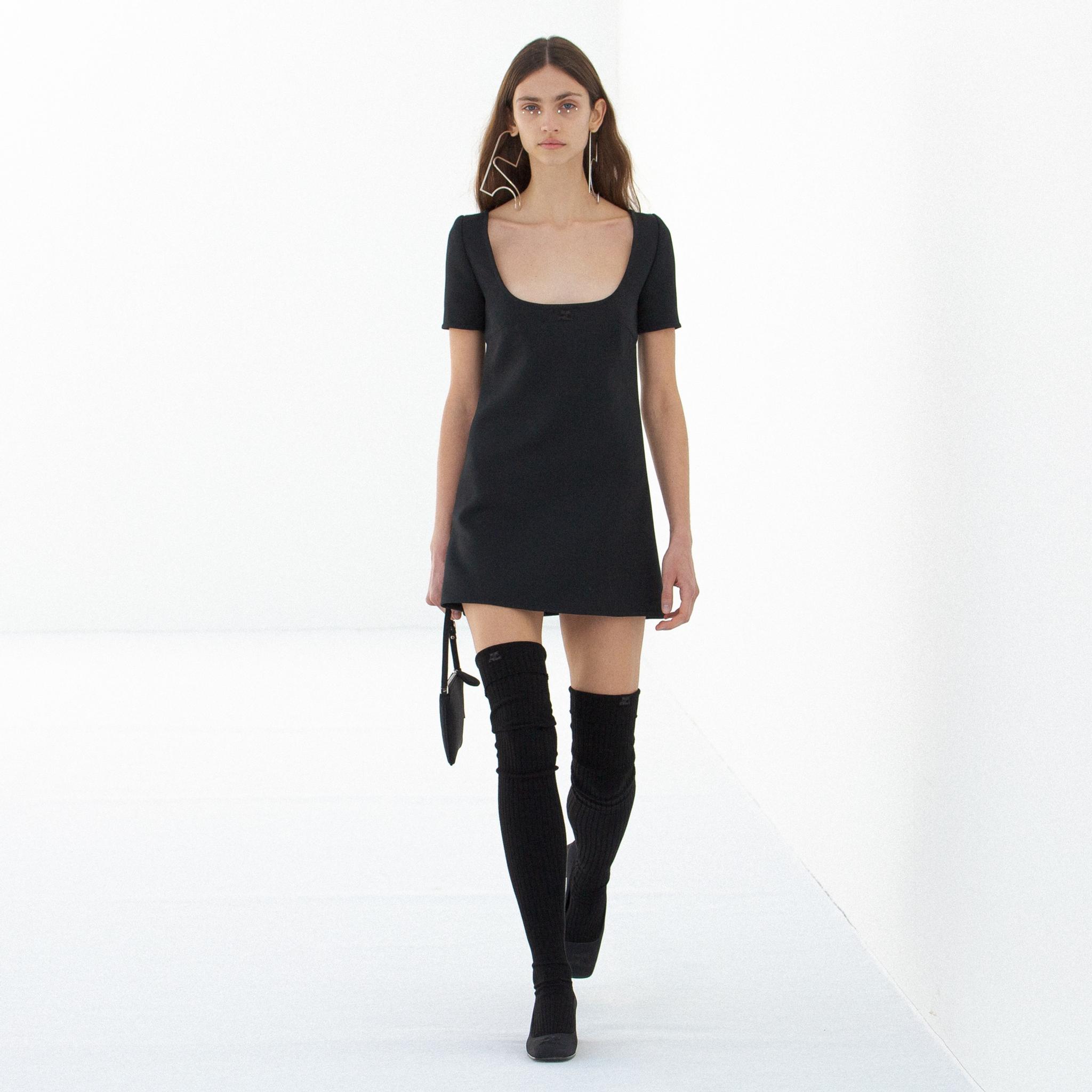 Robe noire élégante avec décolleté carré, représentant le style Courrèges sur un site e-commerce.