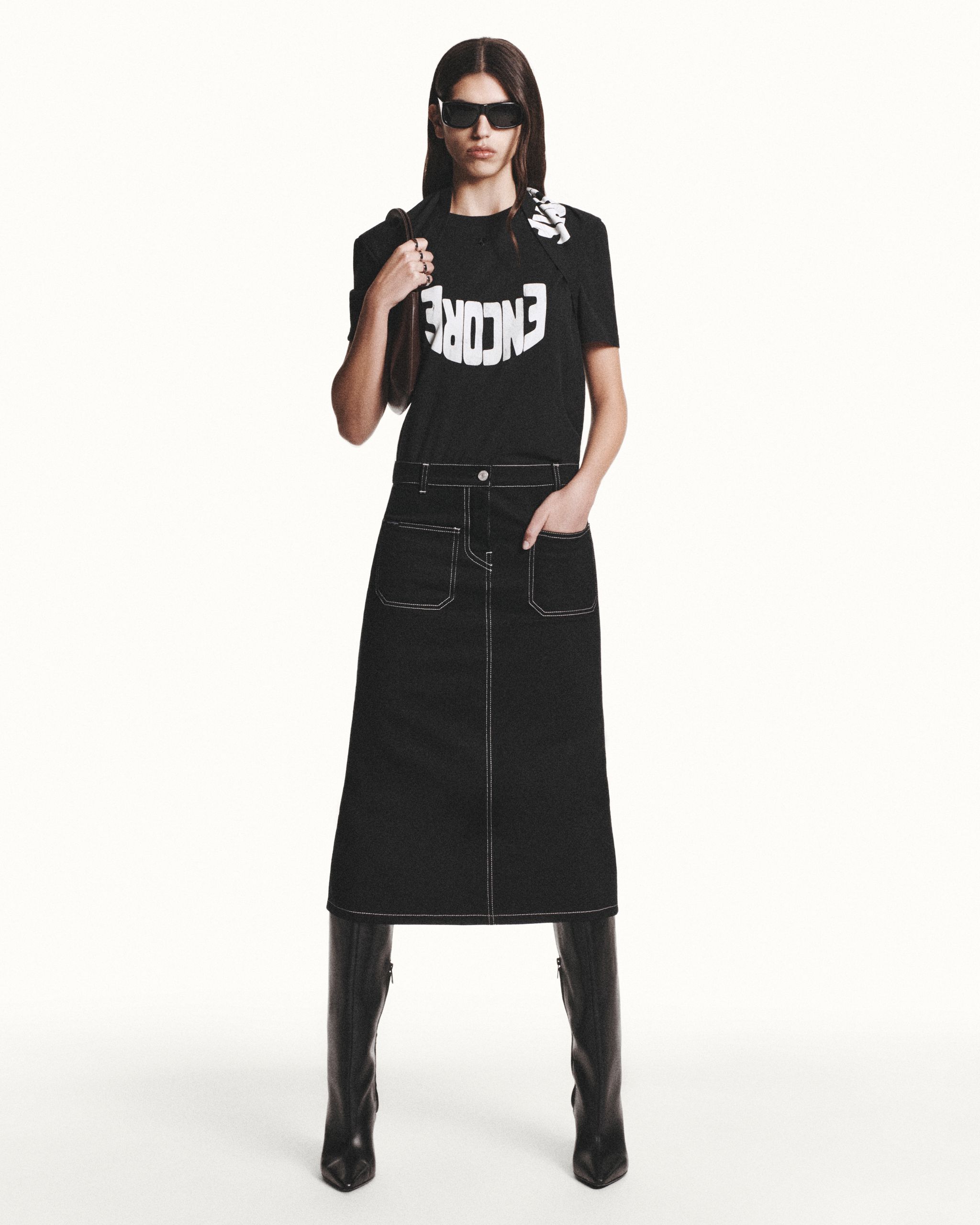 Elegant black fashion ensemble from Courrèges featuring a graphic T-shirt and high boots.