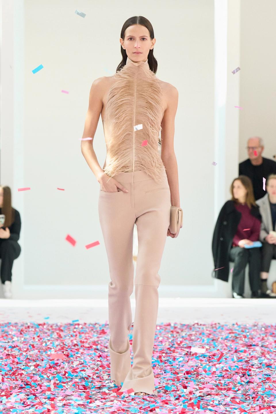 Elegant beige fashion model walking on runway with confetti for Courrèges ecommerce site