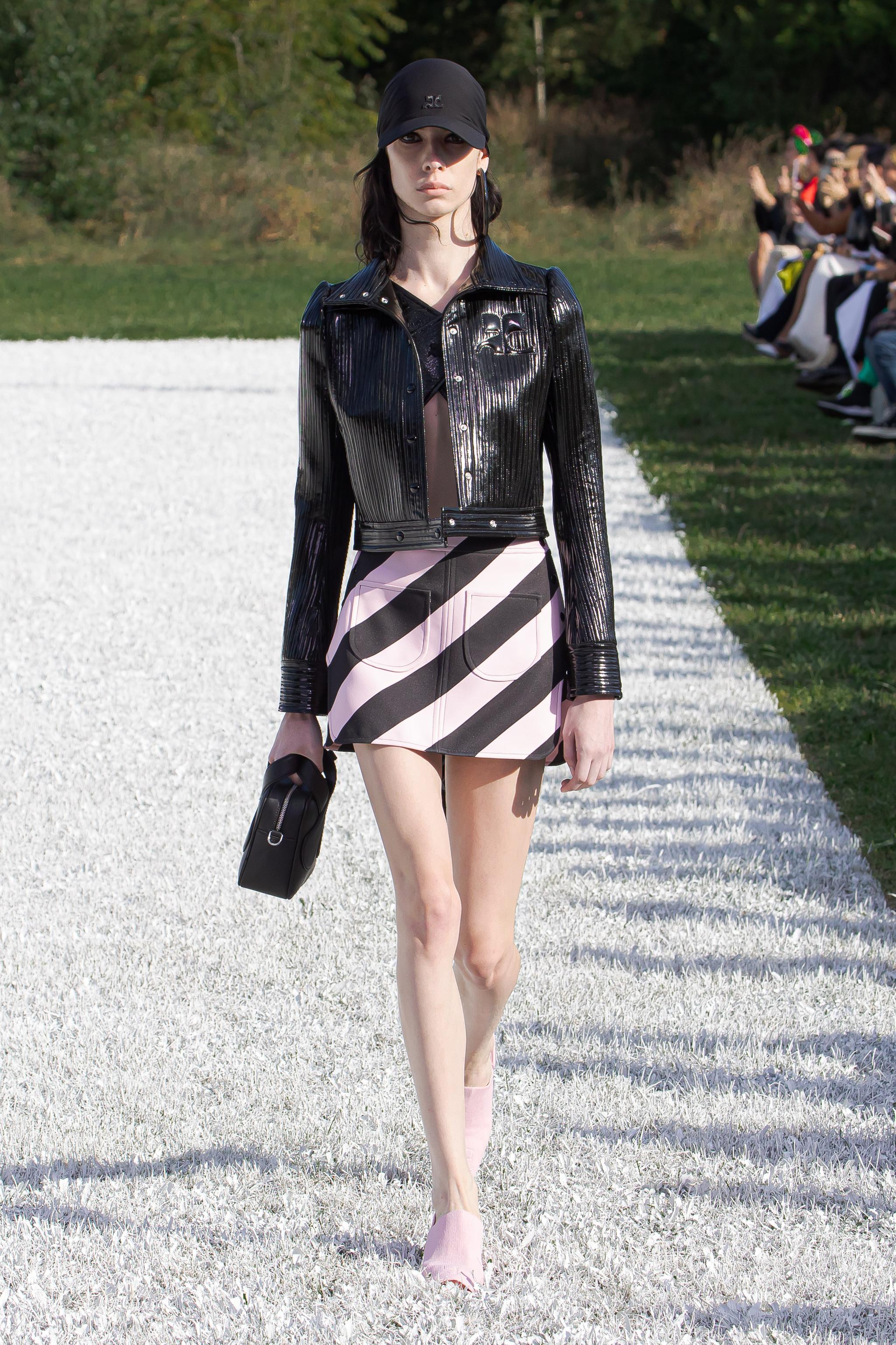 Elegant fashion runway model wearing Courrèges contemporary black patent leather jacket.