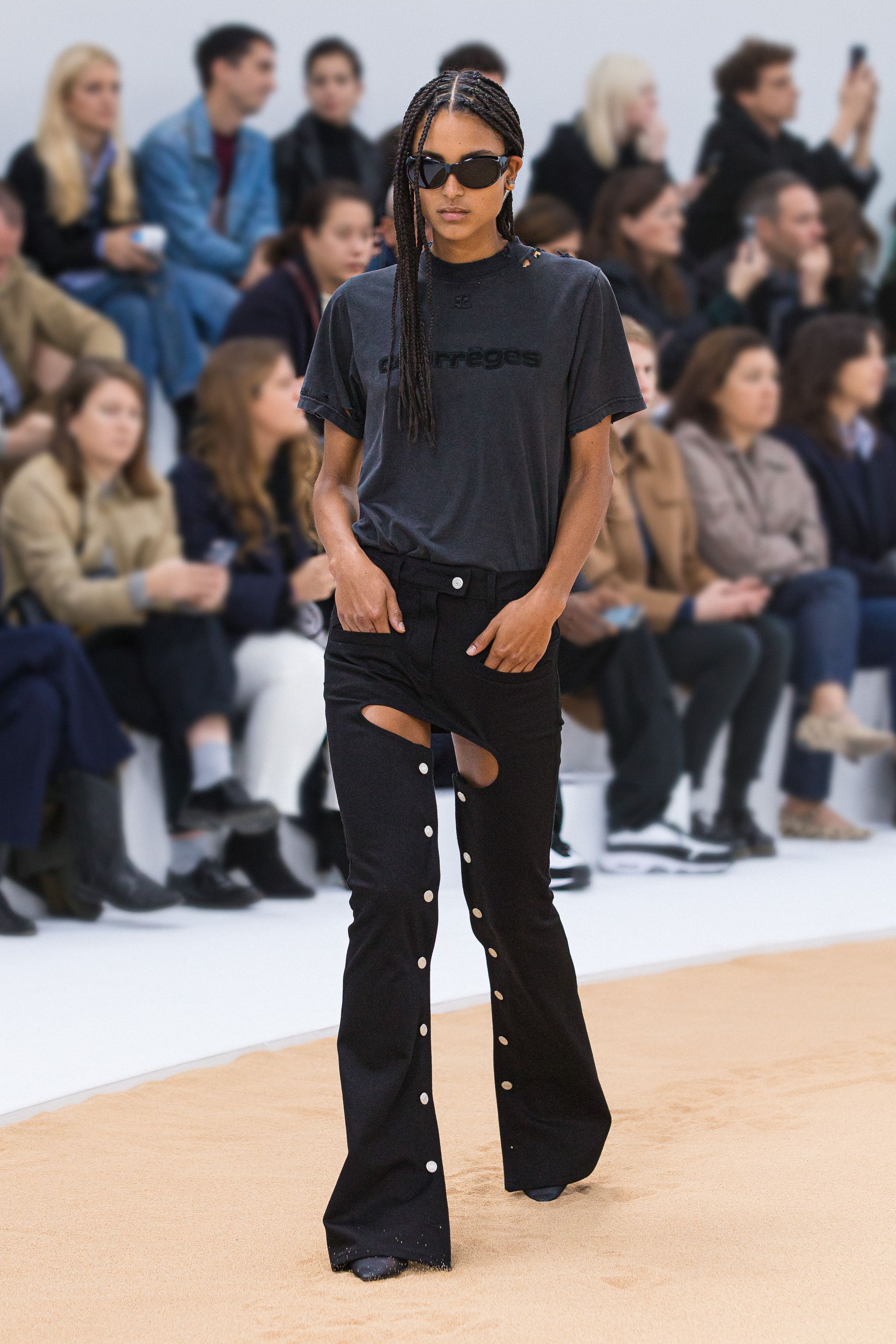 Elegant black streetwear outfit by Courrèges showcased on a runway for contemporary fashion.