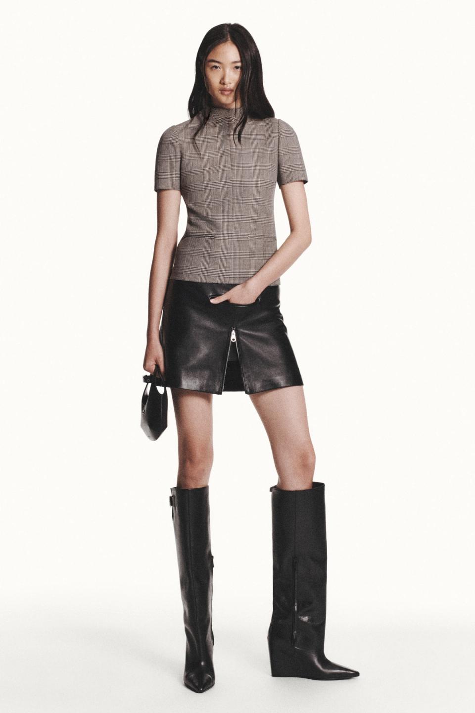 Elegant Courrèges fashion ensemble featuring a plaid top, leather skirt, and over-the-knee boots.