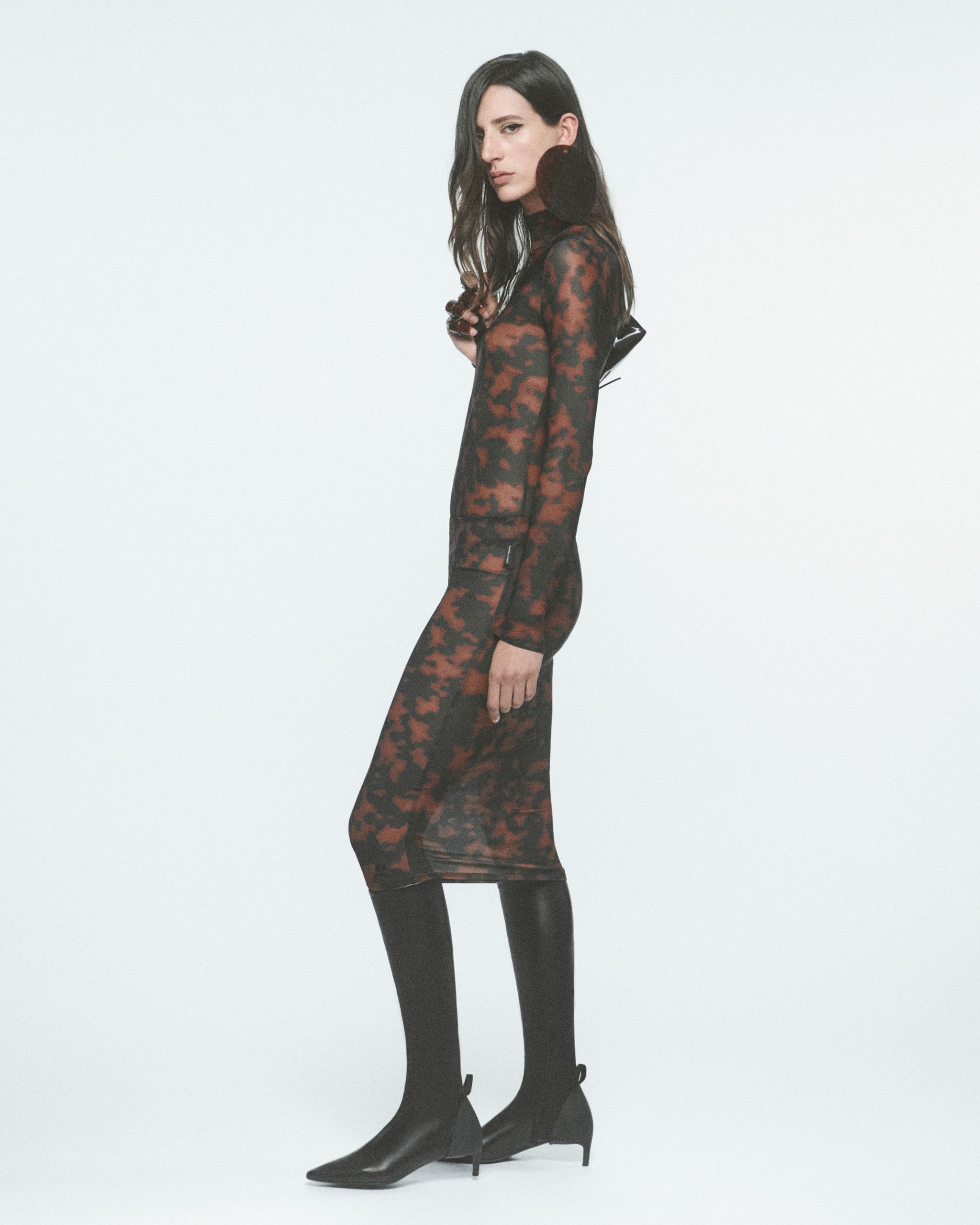 Modèle masculin portant une veste en cuir noir Courrèges et des lunettes de style.