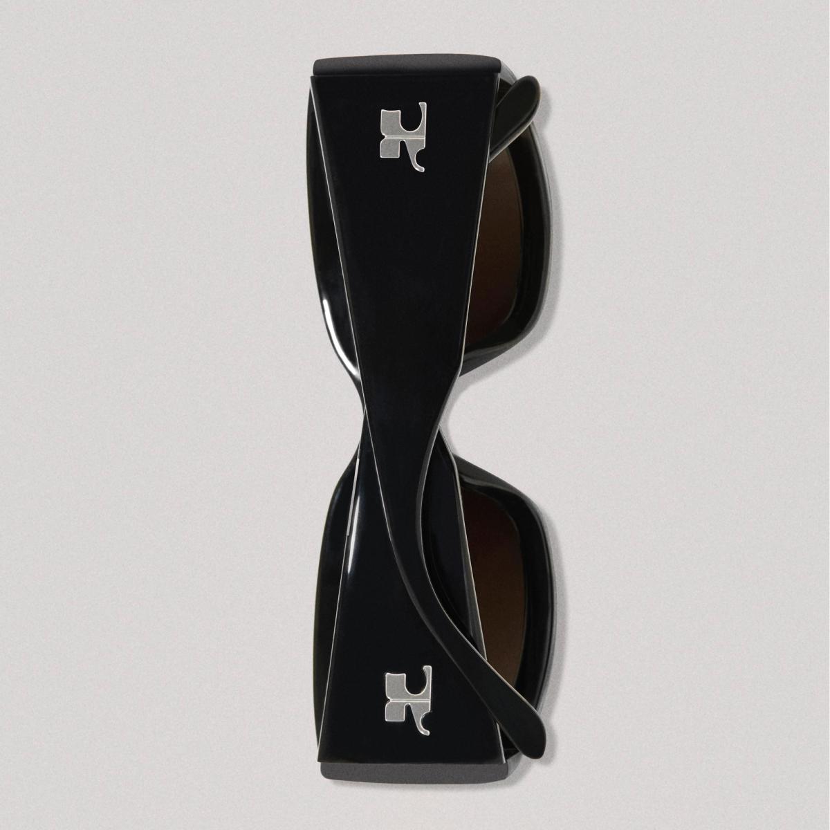 Lunettes de soleil élégantes noires et brunes avec marque Courrèges, pour les amateurs de mode.